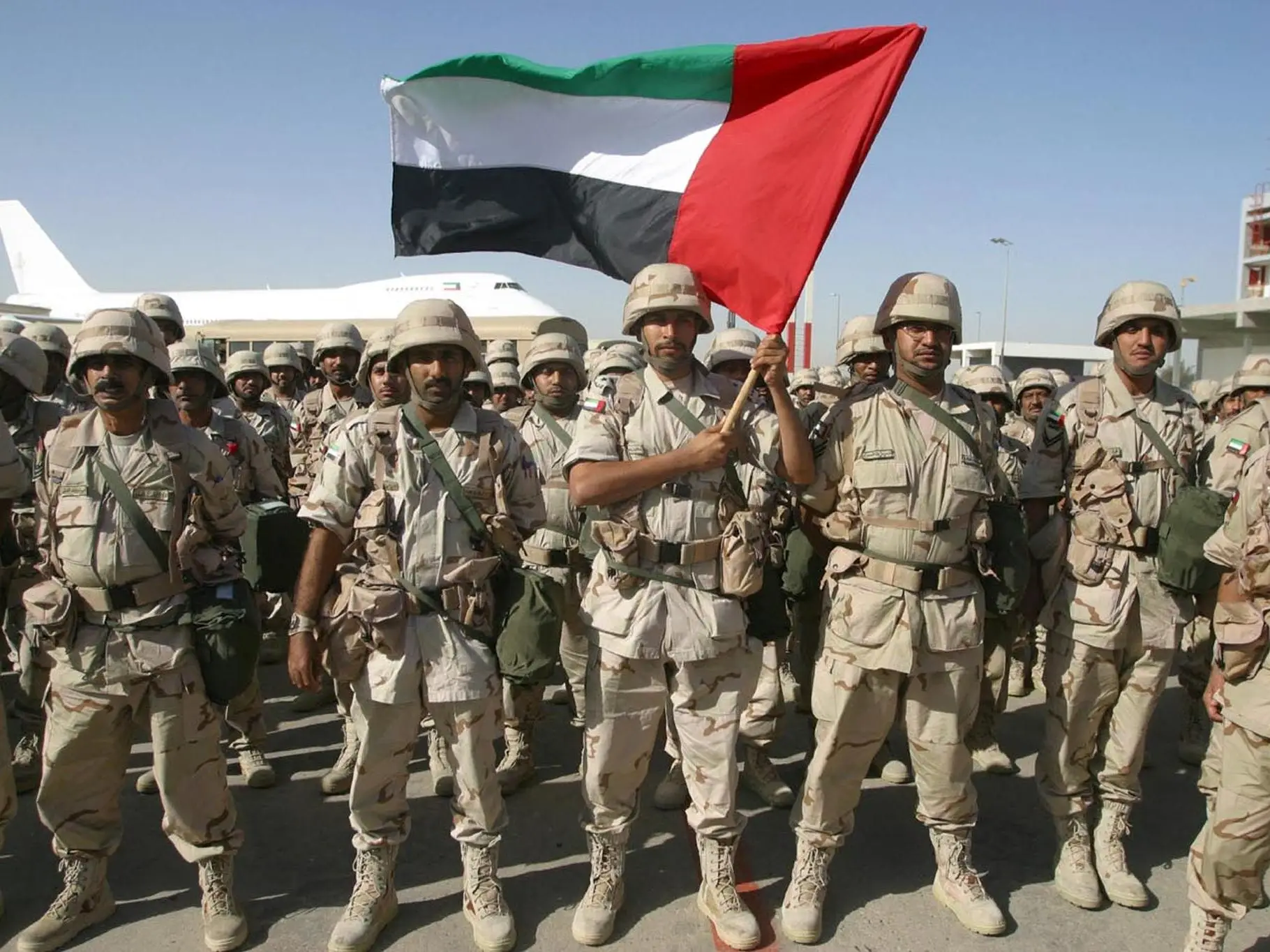 Emirati troops hold the United Arab Emirates flag.