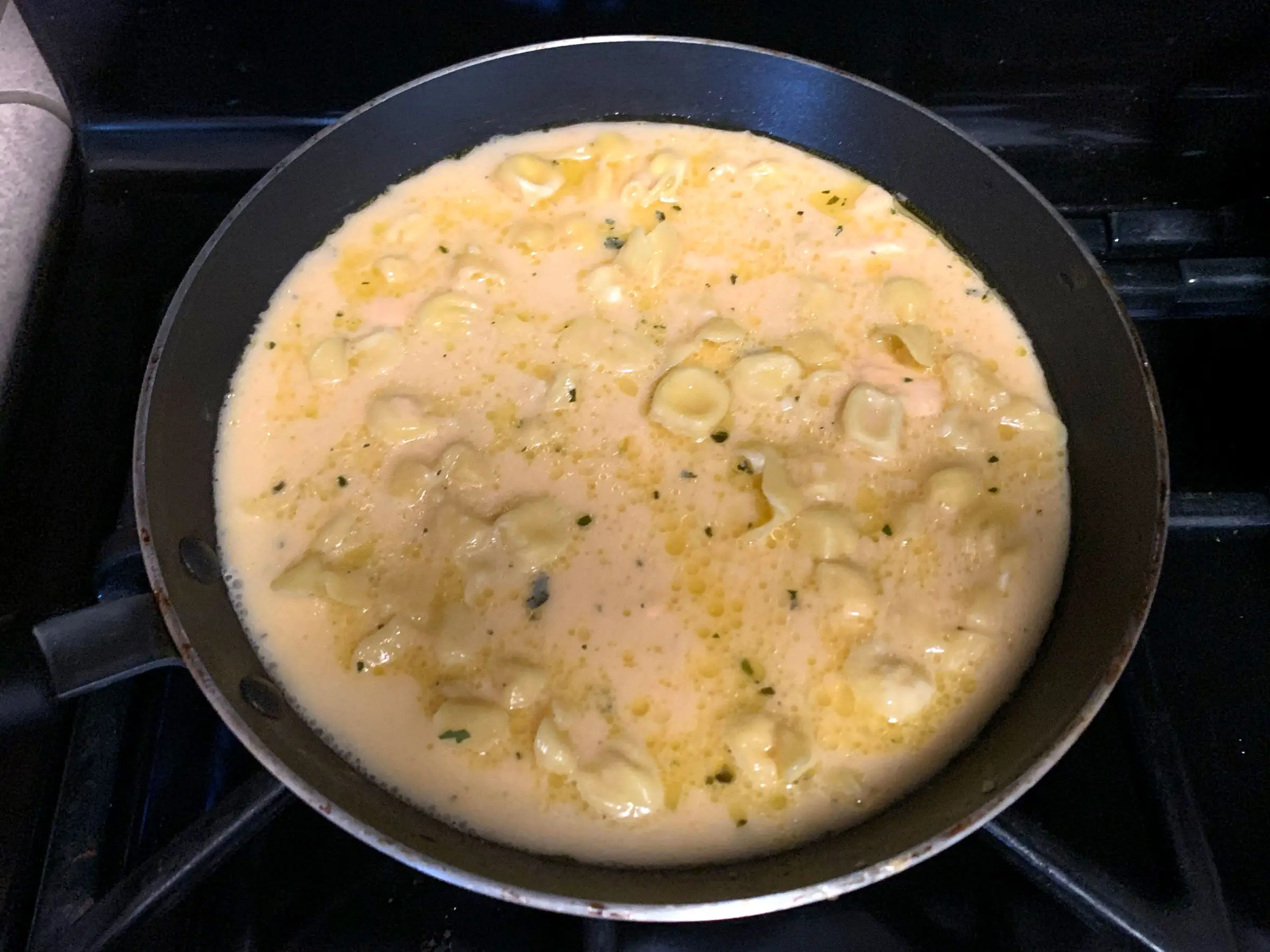 A frying pan of Trader Joe's fiocchetti in a cream sauce.