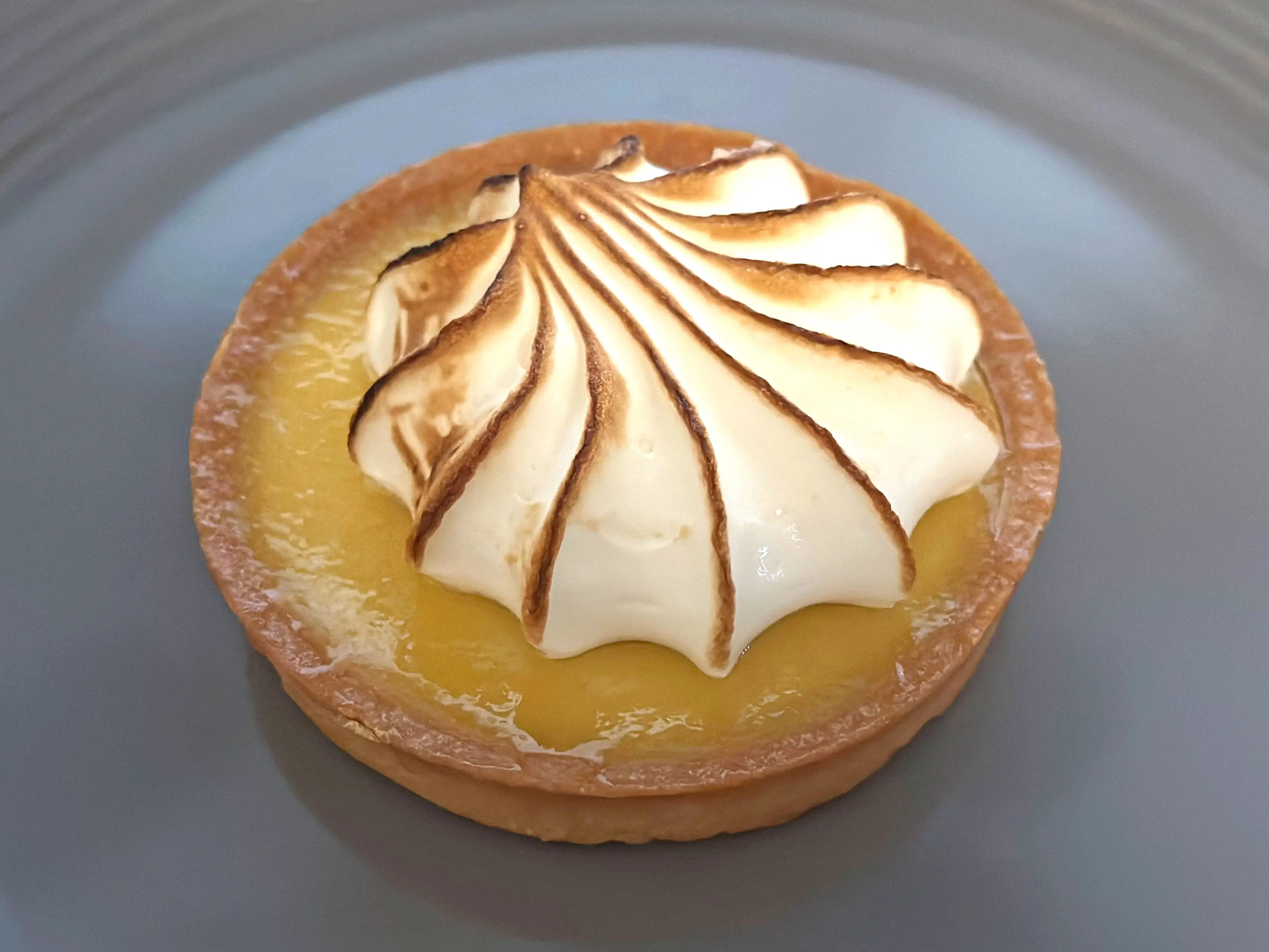 A Trader Joe's passion fruit tartelette on a gray plate.