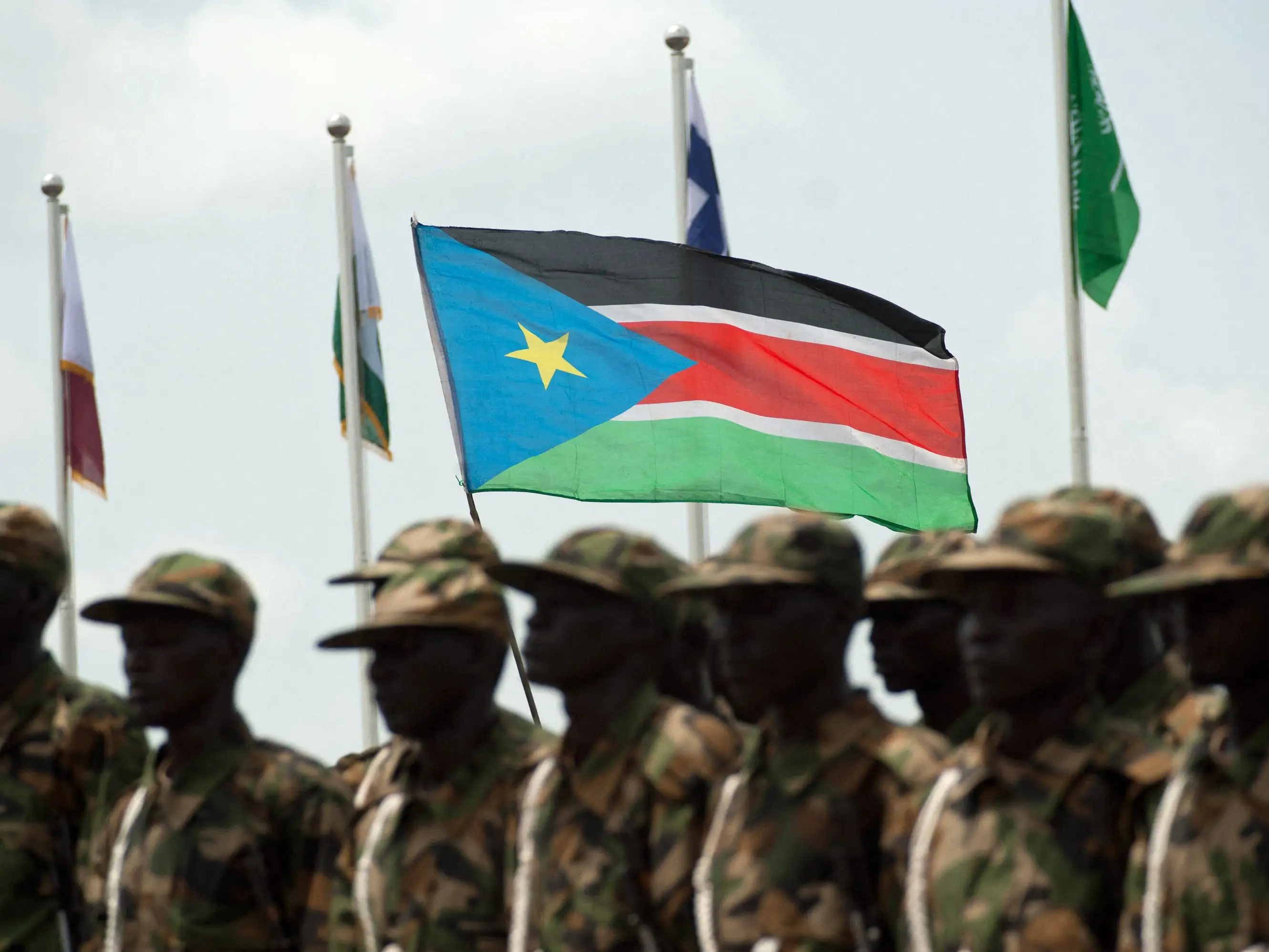 South Sudanese soldiers march with their national flag.