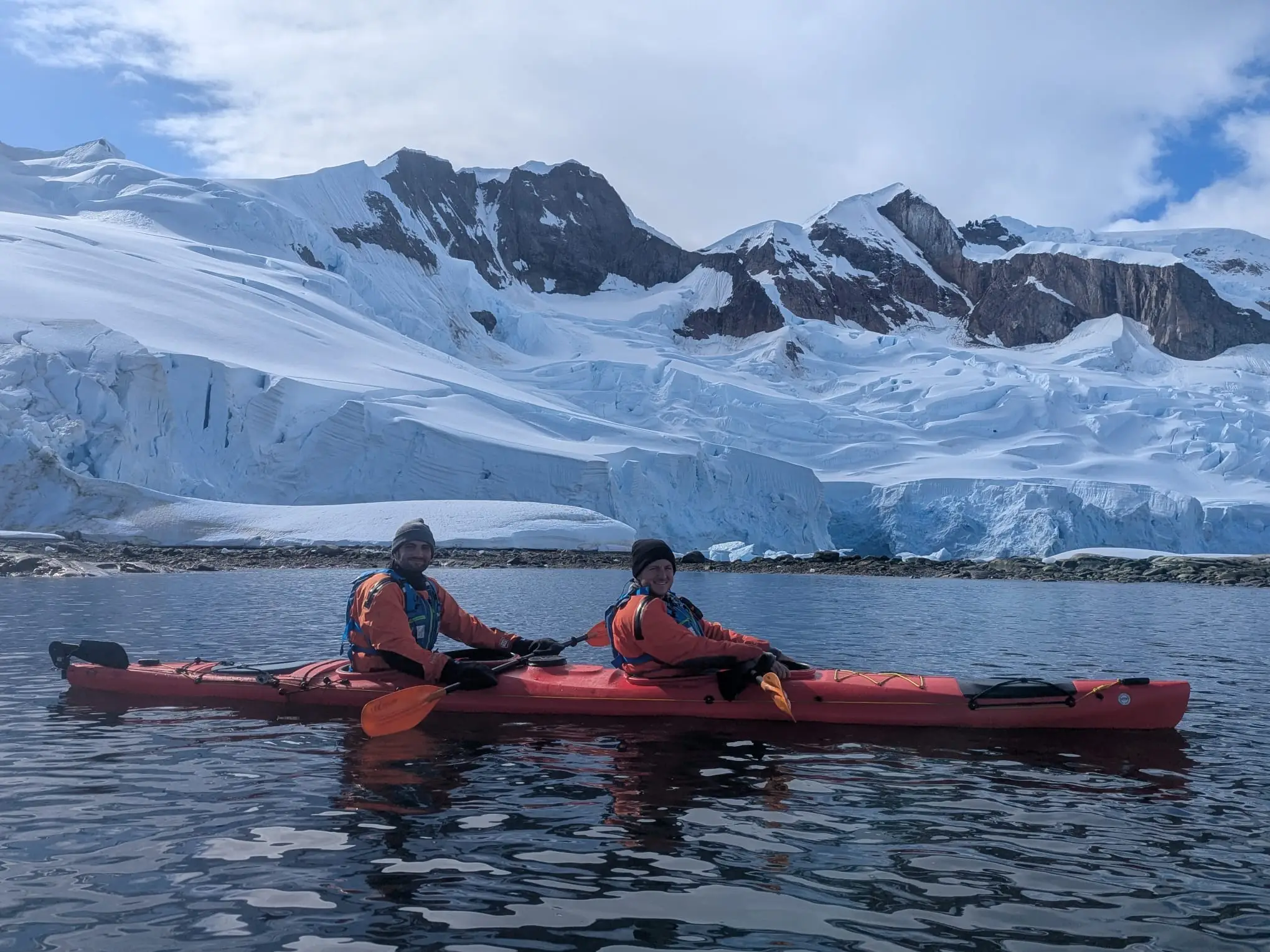 Two friends kayaking around glaciers in Antarctica.