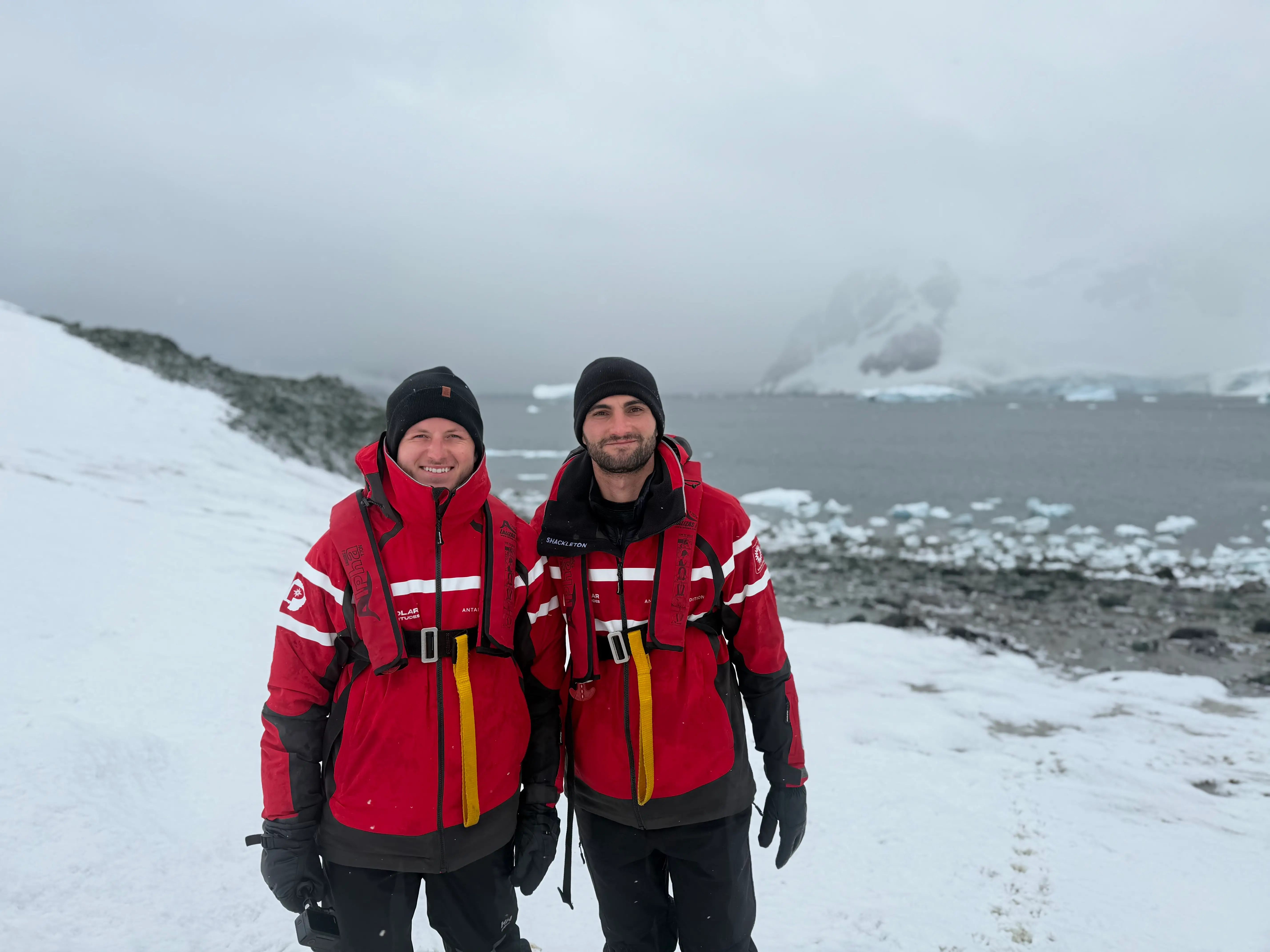 Two friends in red jackets in Antarctica.