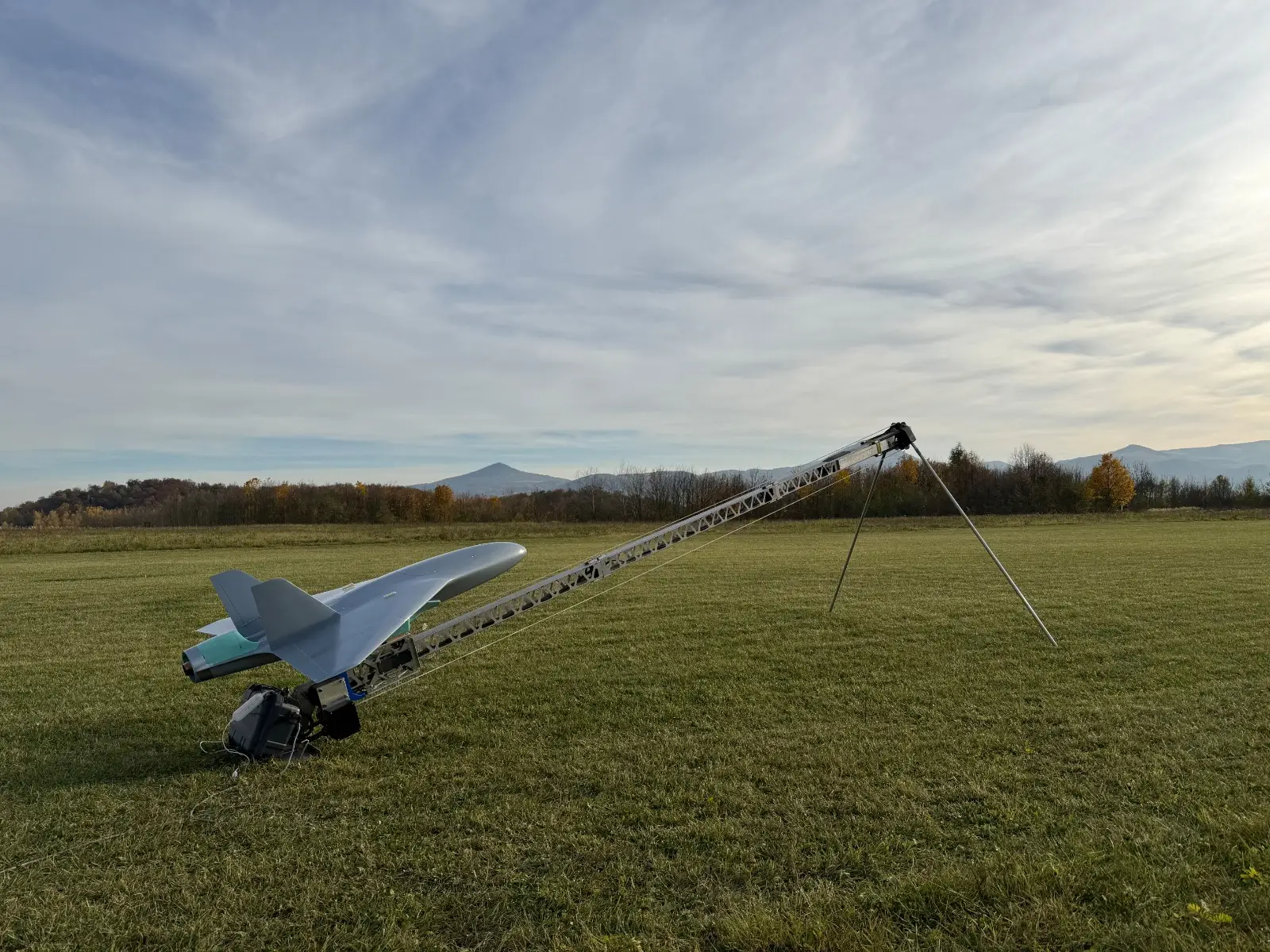 A jet-powered interceptor drone sits on a launch platform in an open field.