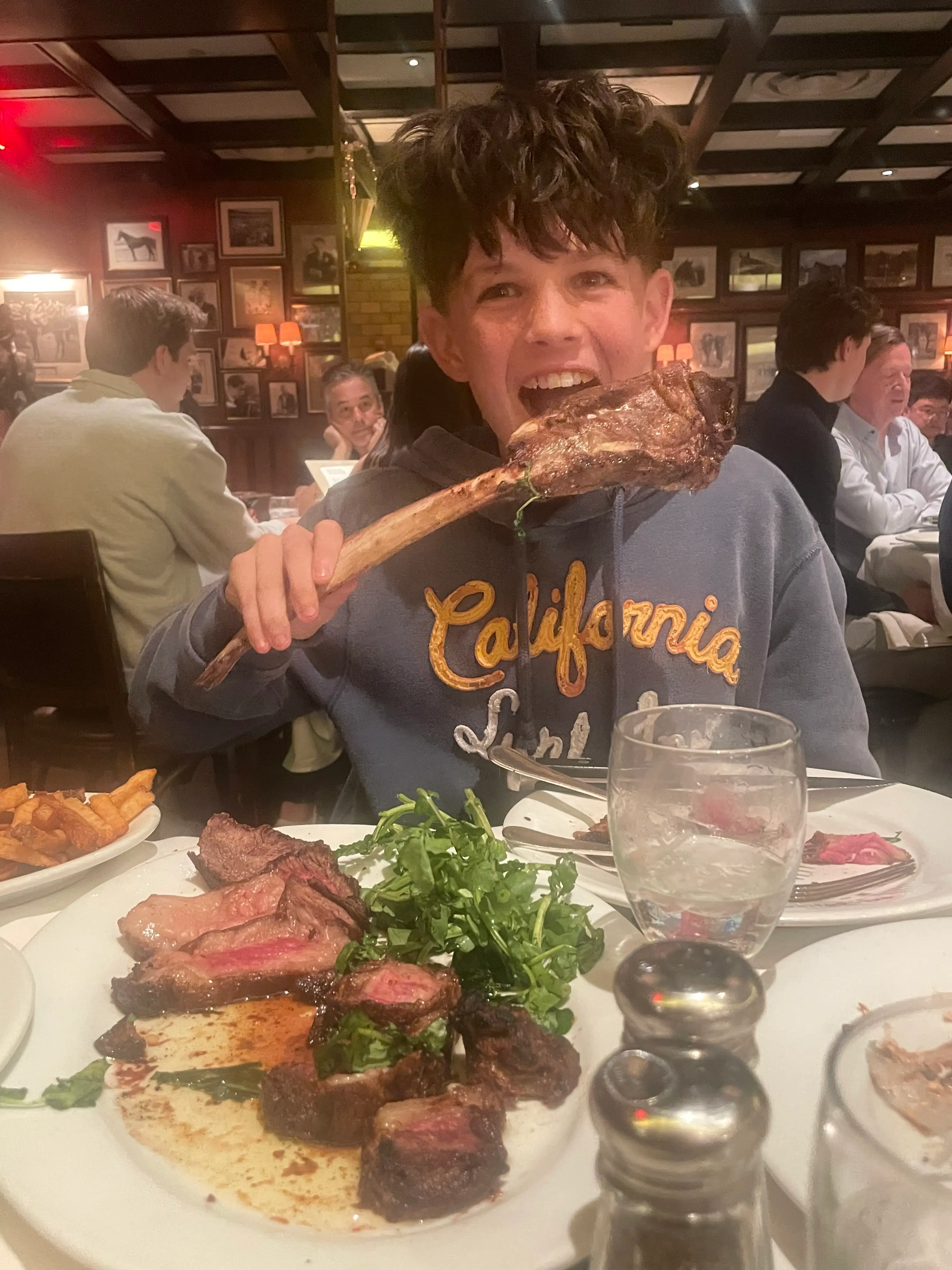 The author's son enjoys a steak dinner in NYC.