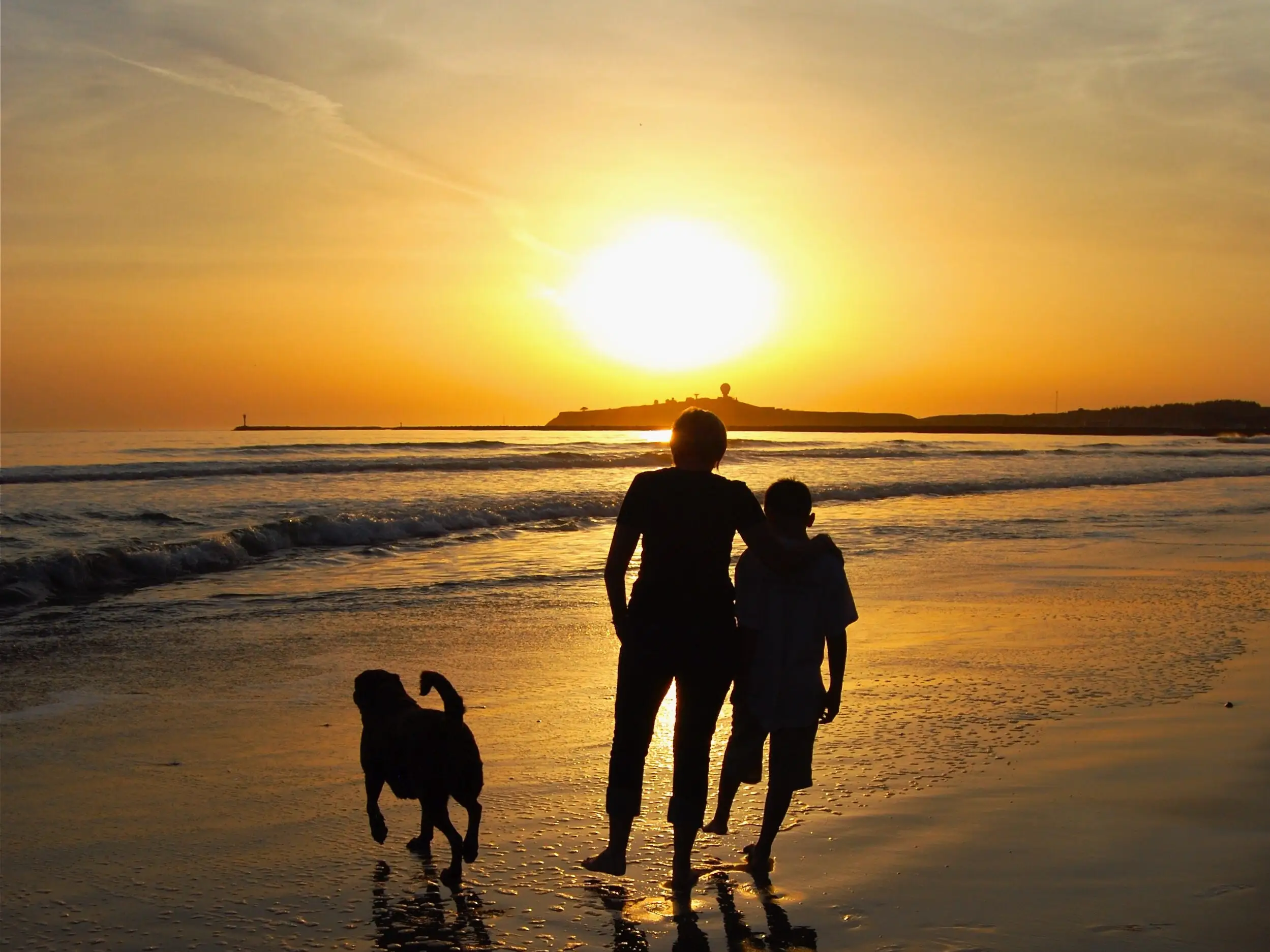 Mom and son walking on beach