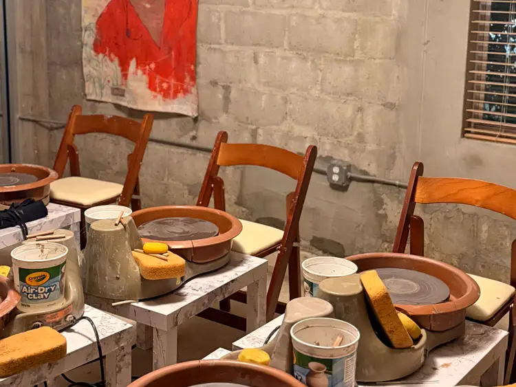 Tables and chairs with pottery equipment set up.