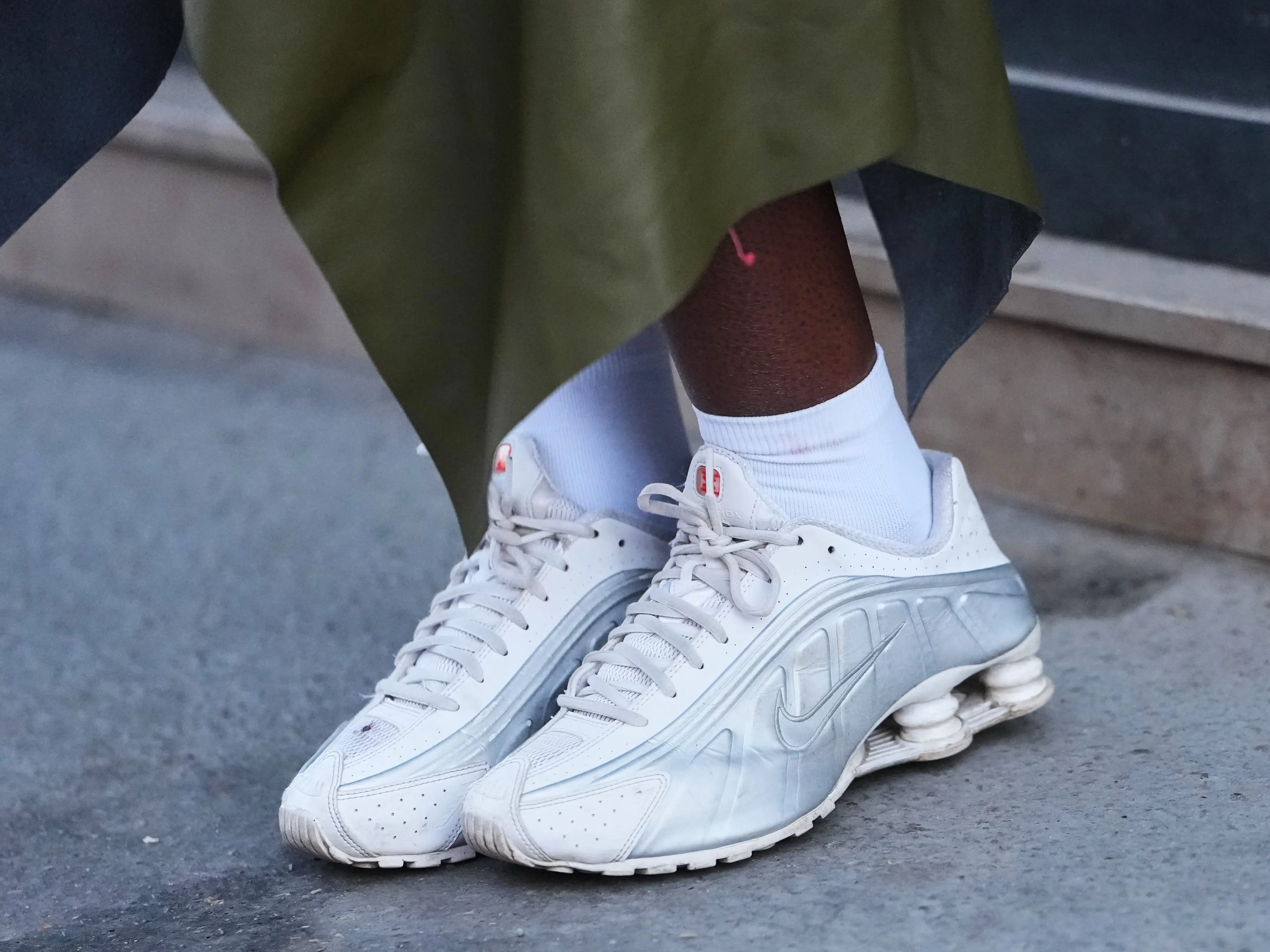A woman wearing a pair of white sneakers.