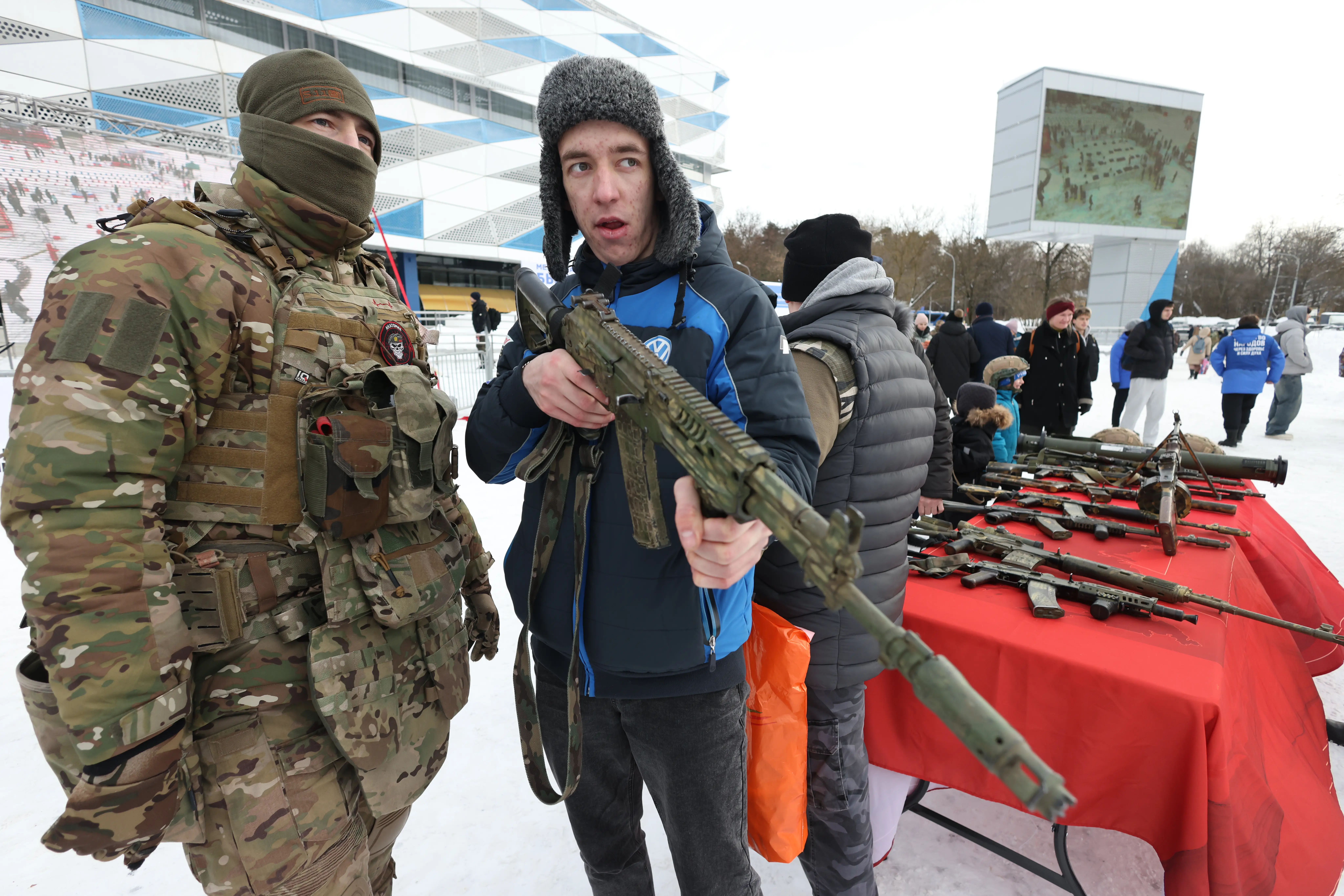 A Russian military serviceman speaks with an attendee at a military festival.
