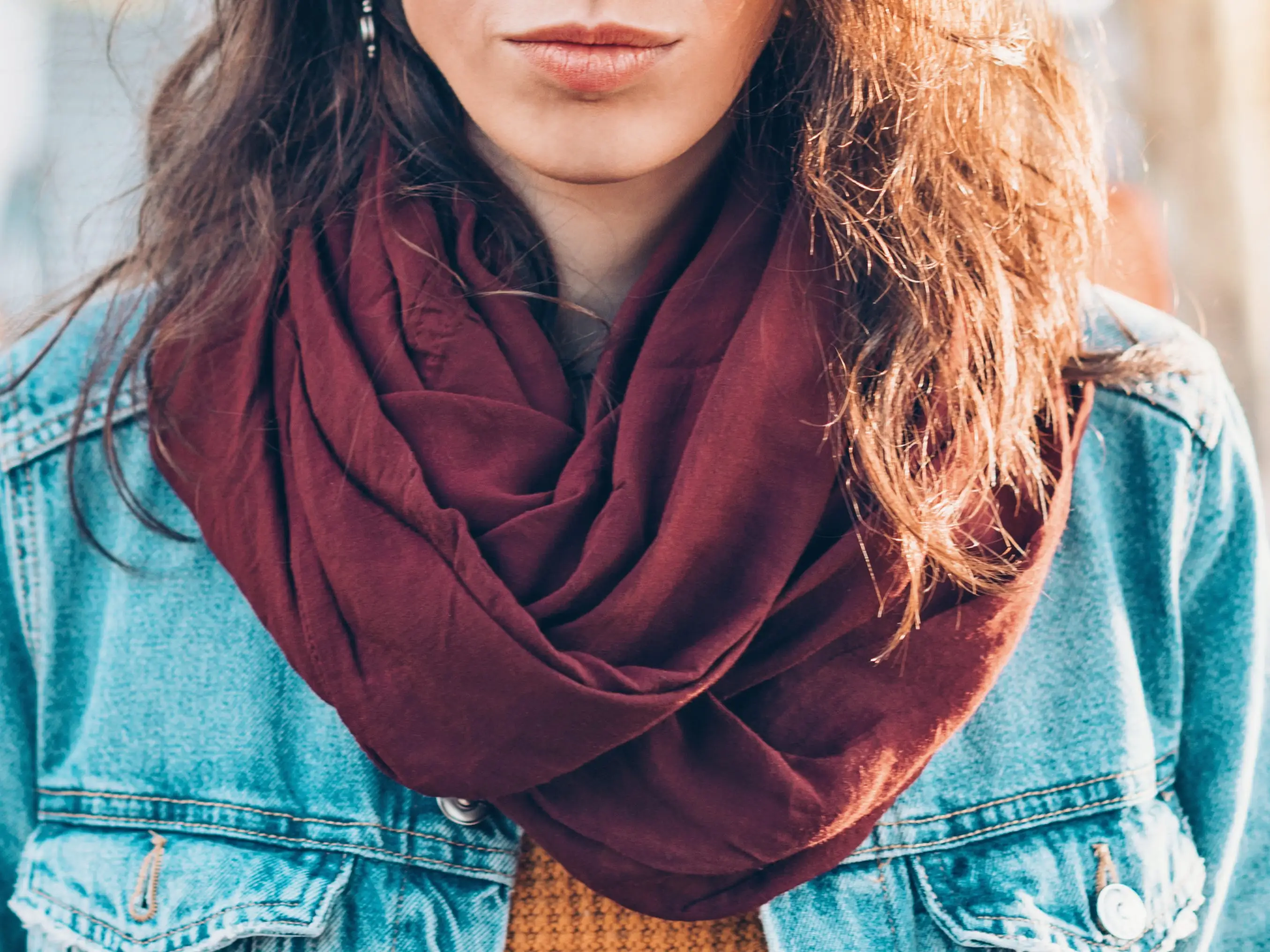 A woman wearing a burgundy infinity scarf.