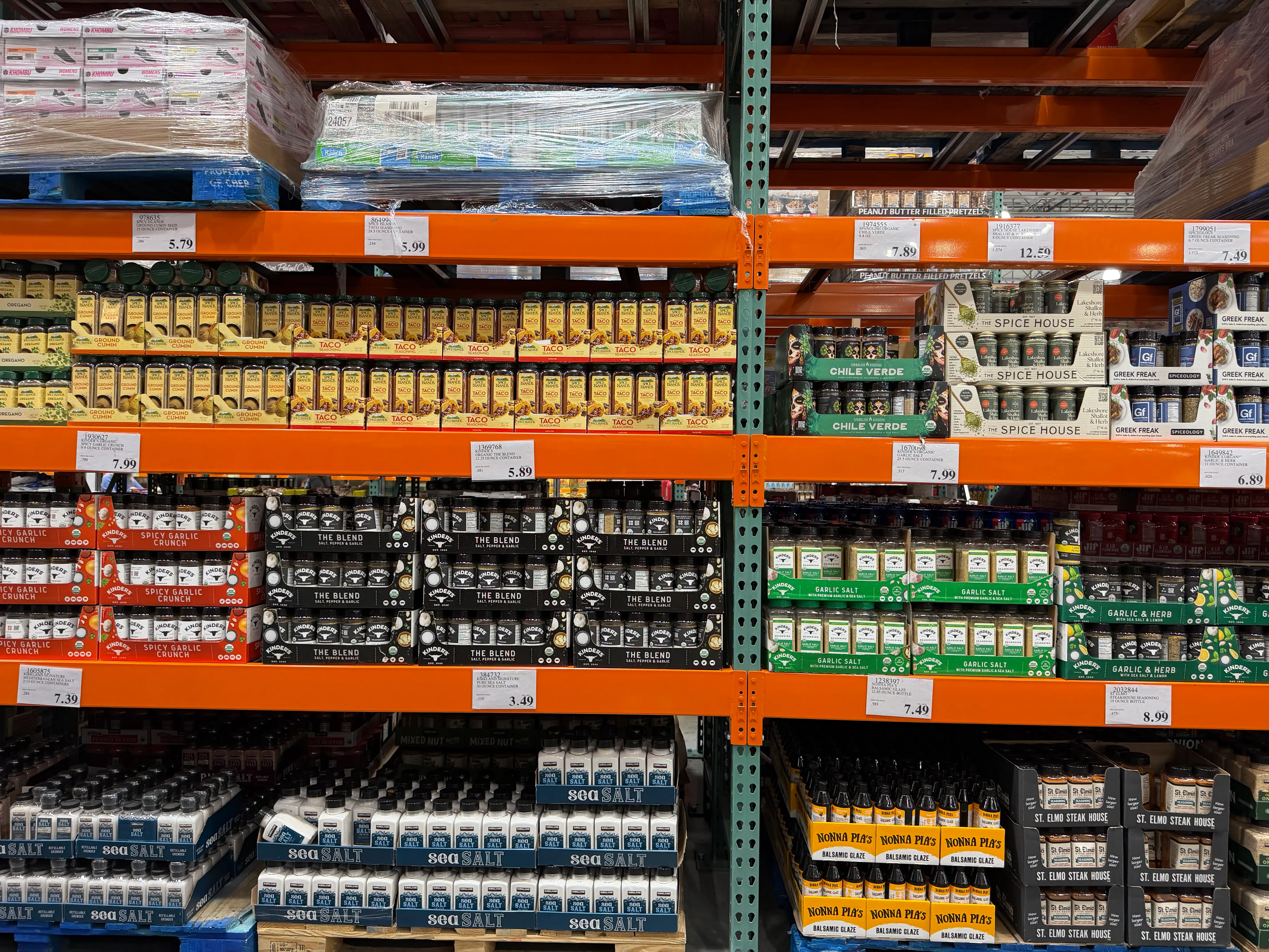 Spice aisle at Costco with large containers of spices on orange shelves