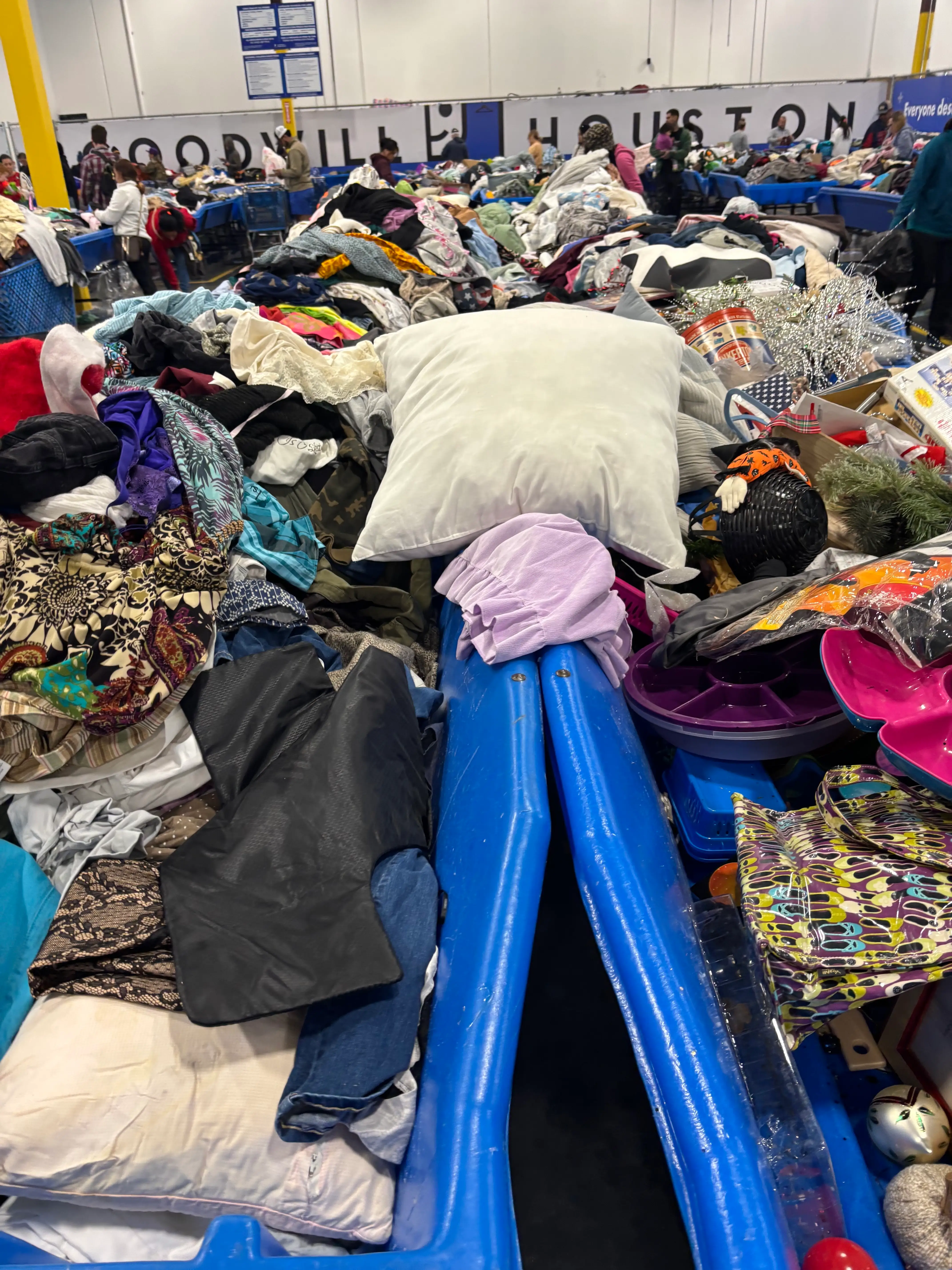 A picture of bins willed with clothes and other items at Goodwill.