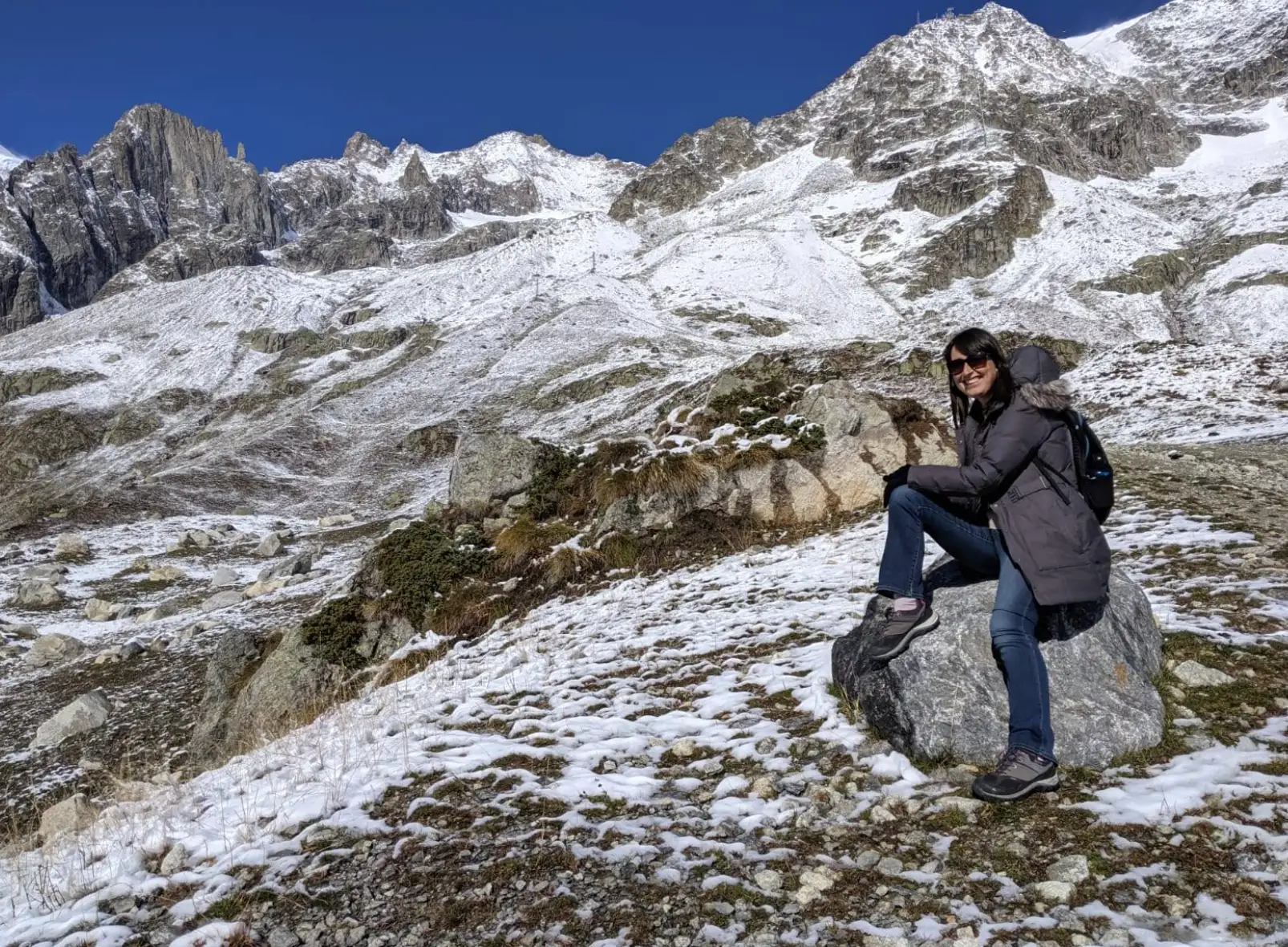 The writer standing on a rock on a snowy mountain in the Alps.