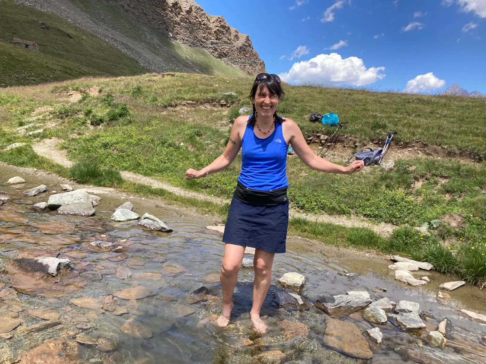 The writer standing in a creek in the summertime.