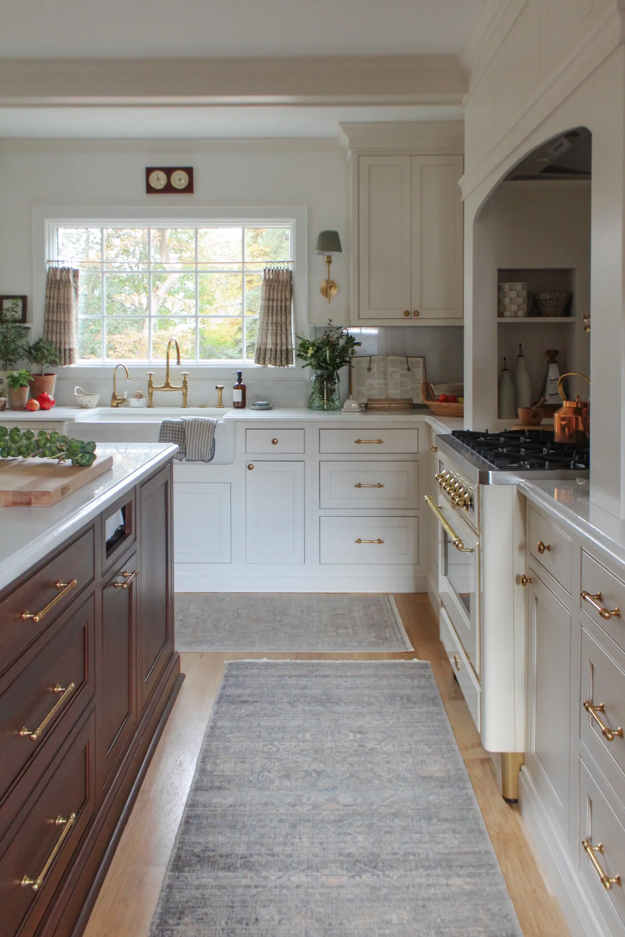A kitchen with white countertops and cabinets and a wooden island.