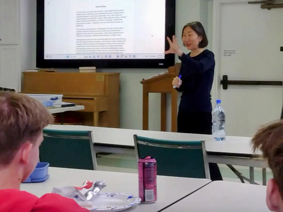 Diana Ha teaching a class with an essay on the screen