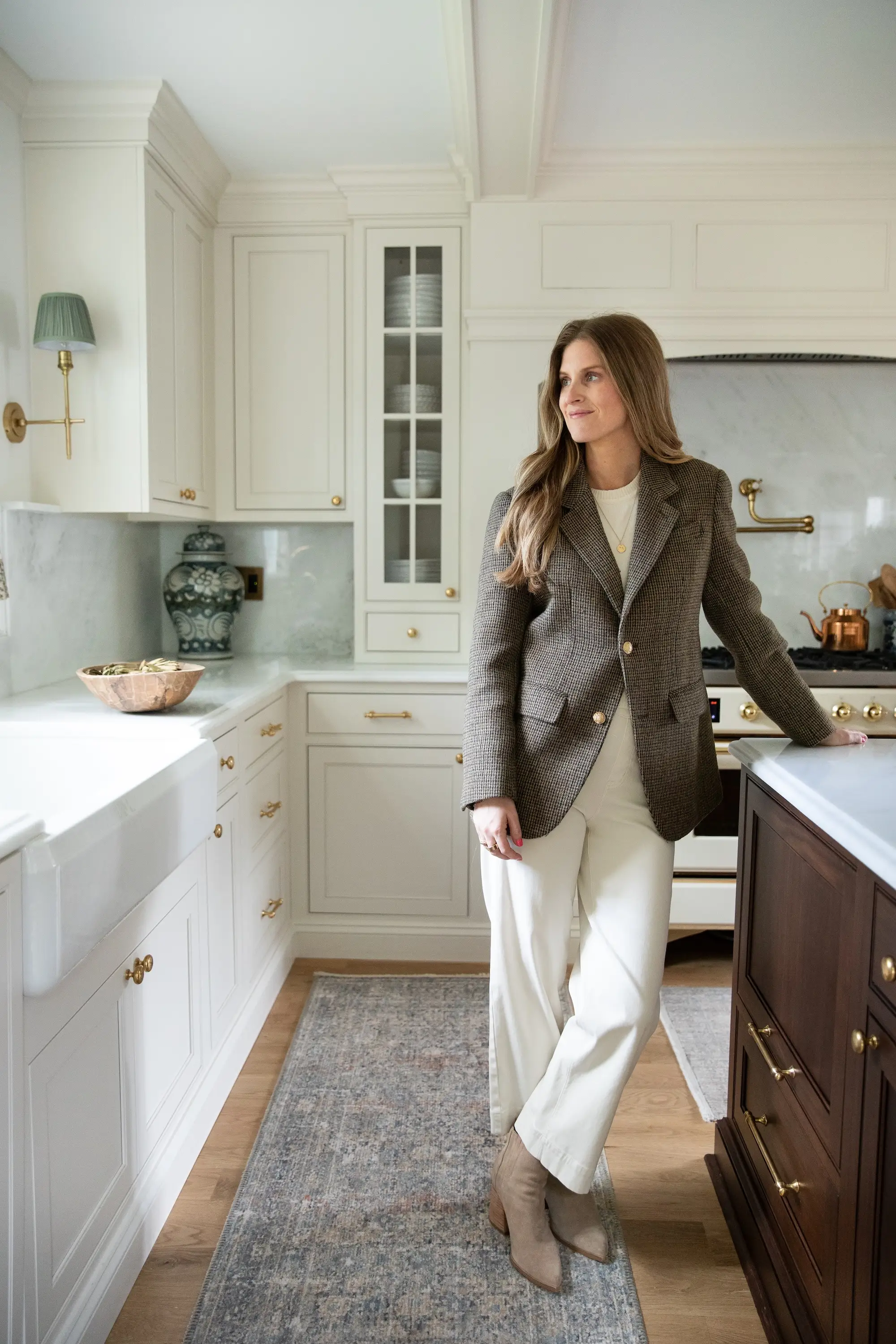 A woman smiles in the distance in her kitchen.