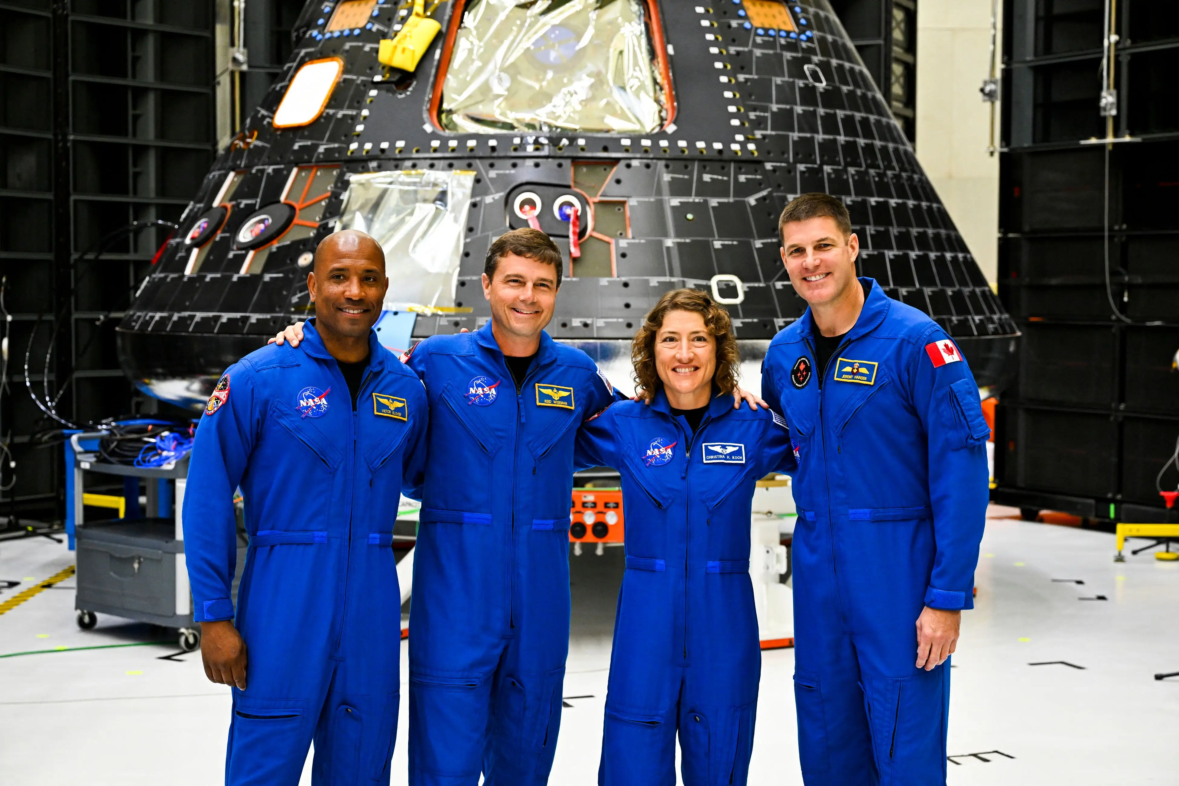 astronauts Victor Glover, pilot; Reid Wiseman, commander; Christina Hammock Koch, mission specialist; and Canadian astronaut Jeremy Hansen, mission specialist, pose with the Artemis II crew module
