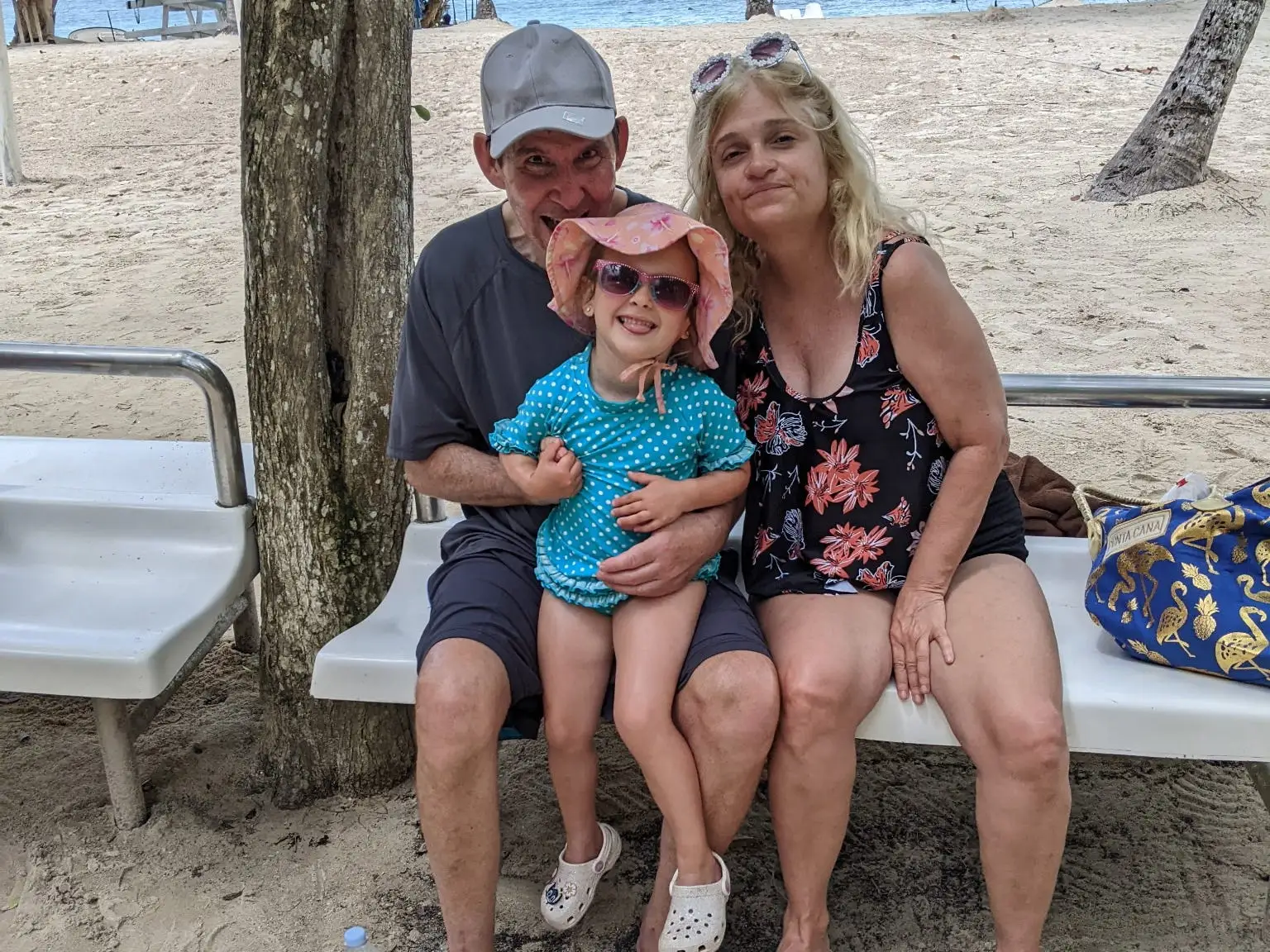 Grandparents with their granddaughter on a beach.