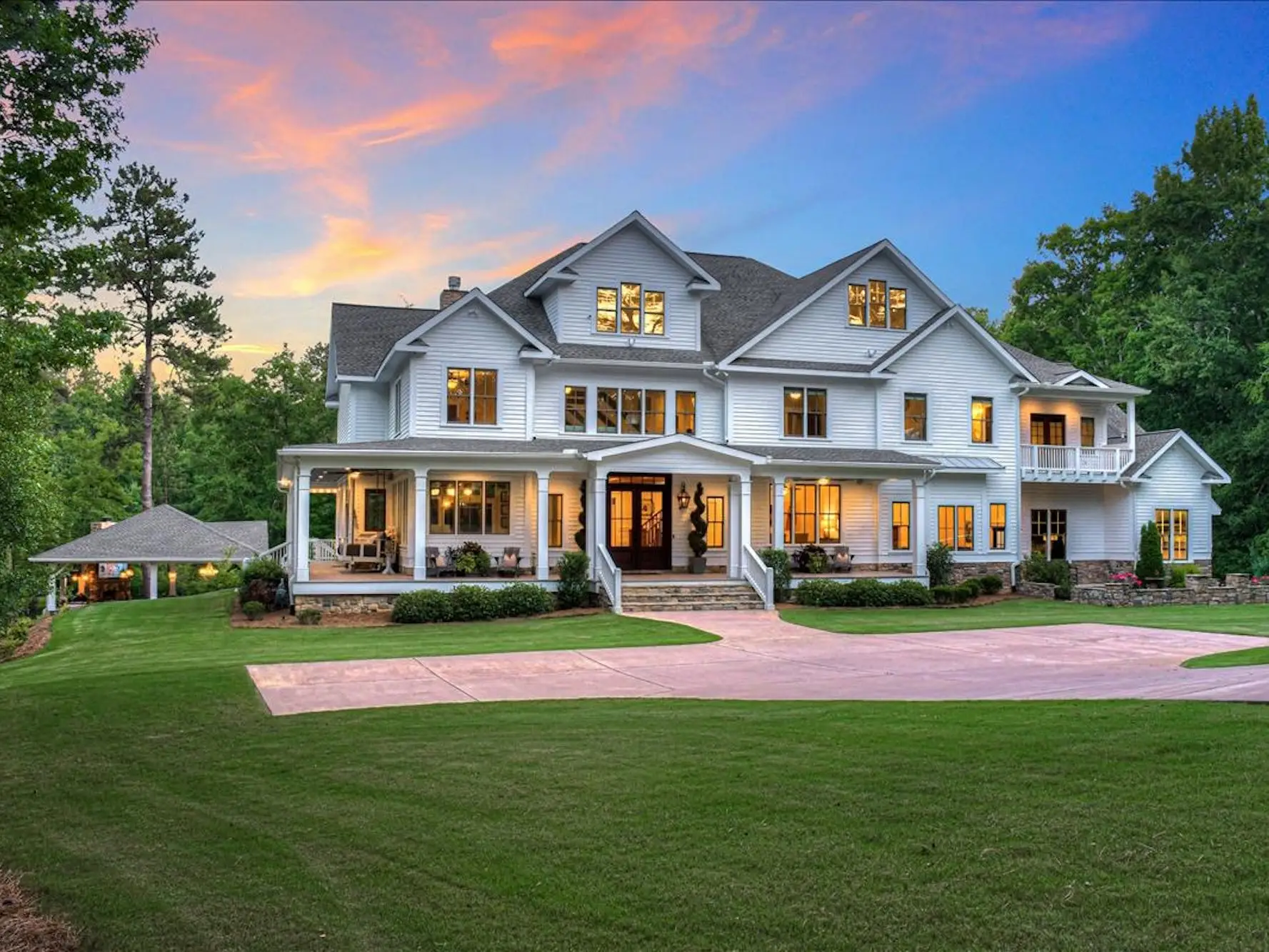 A large white house with a large green lawn.