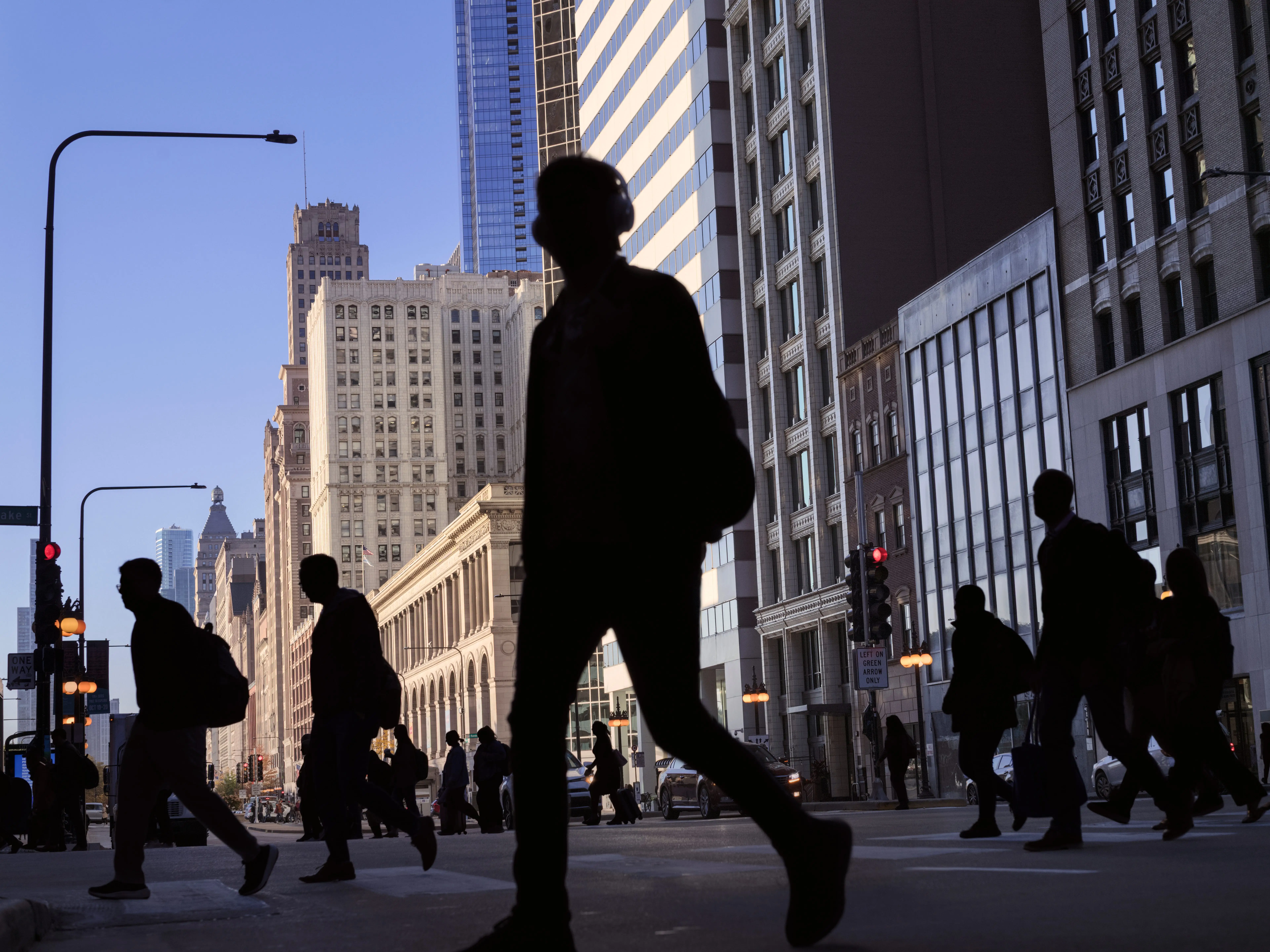 Silhouettes of workers crossing the street in a metropolitan area