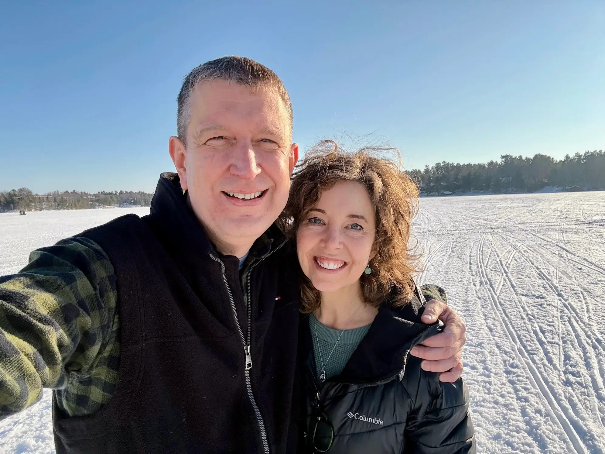 Jennie Young and a man standing on a ground covered in snow.