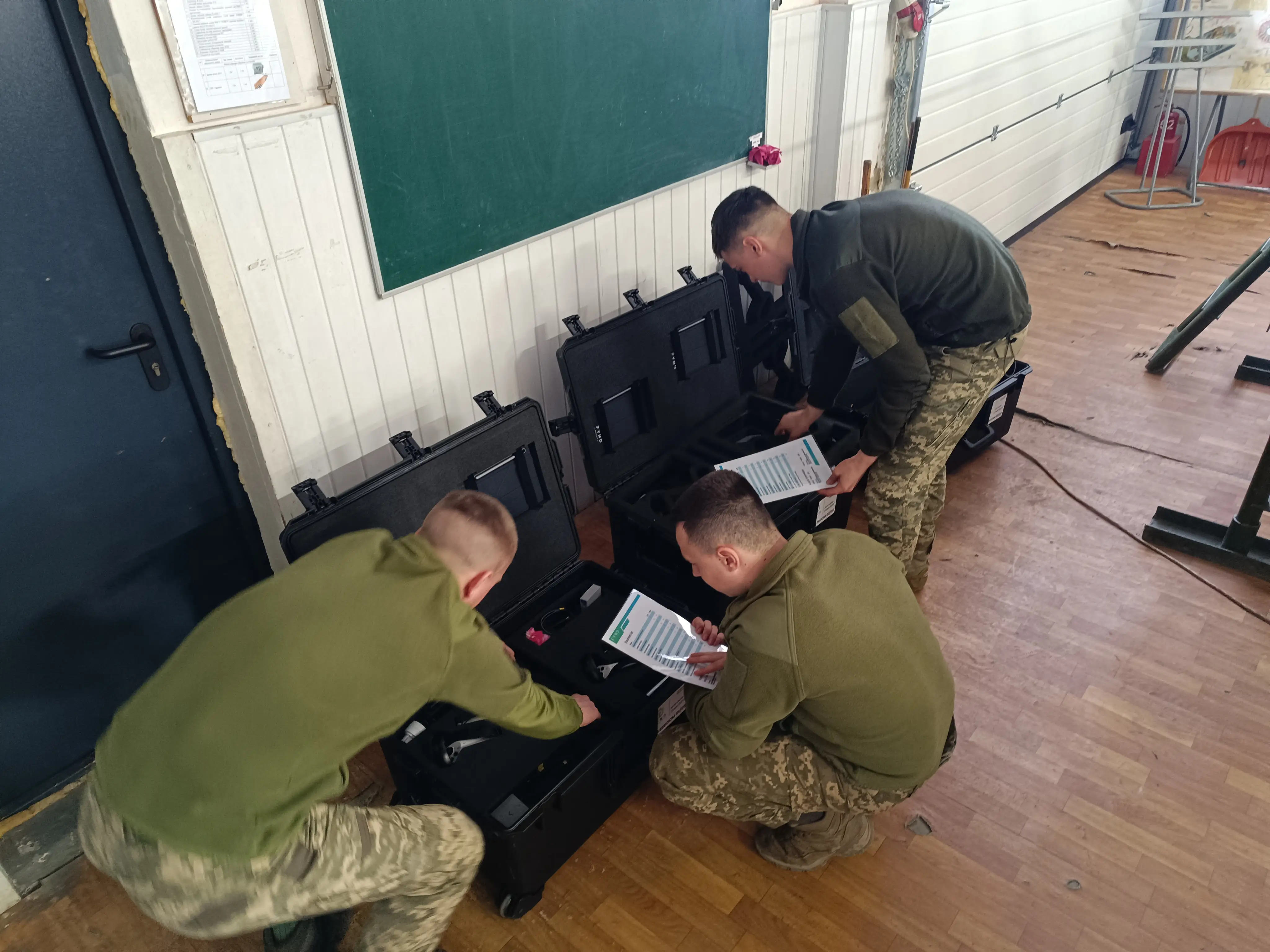 Three Ukrainians stand over crates containing Varjo's training systems.