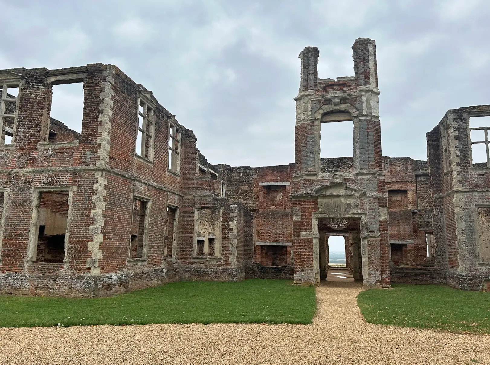 Historic ruins near the water, with cloudy skies overhead.