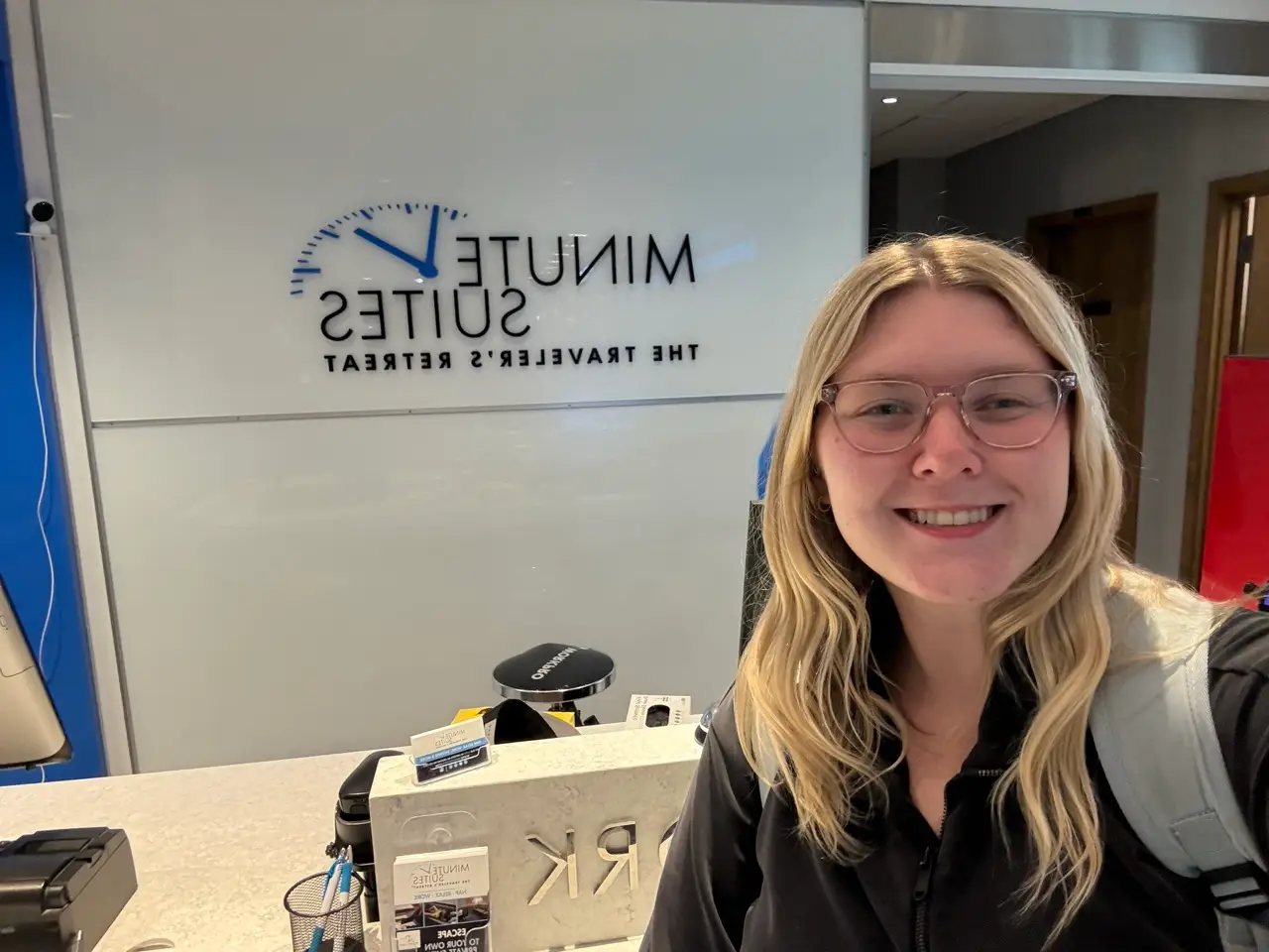 Woman smiling in front of Minute Suites sign