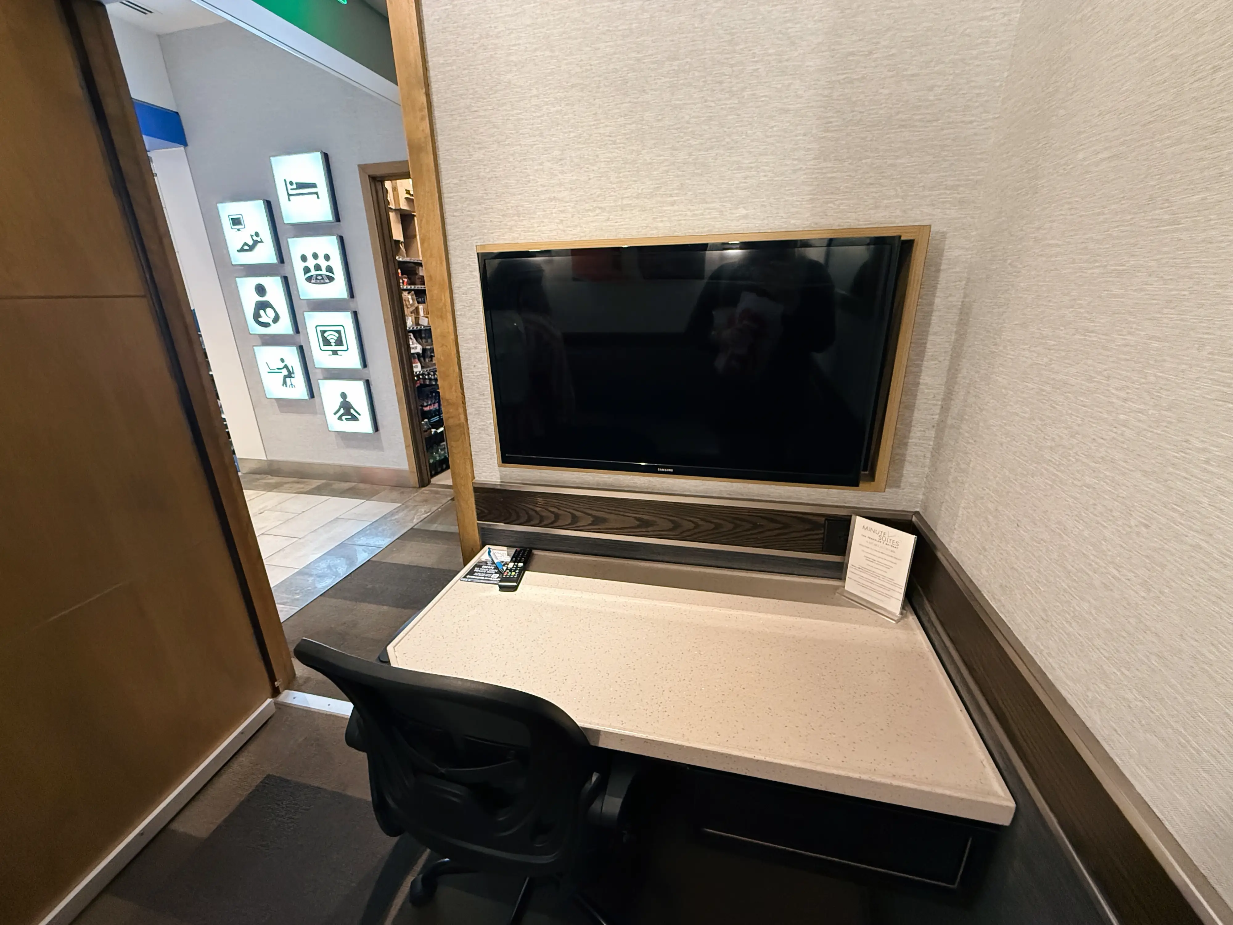 TV over desk with chair in front of it in Minute Suites CLT Gold Rush Room
