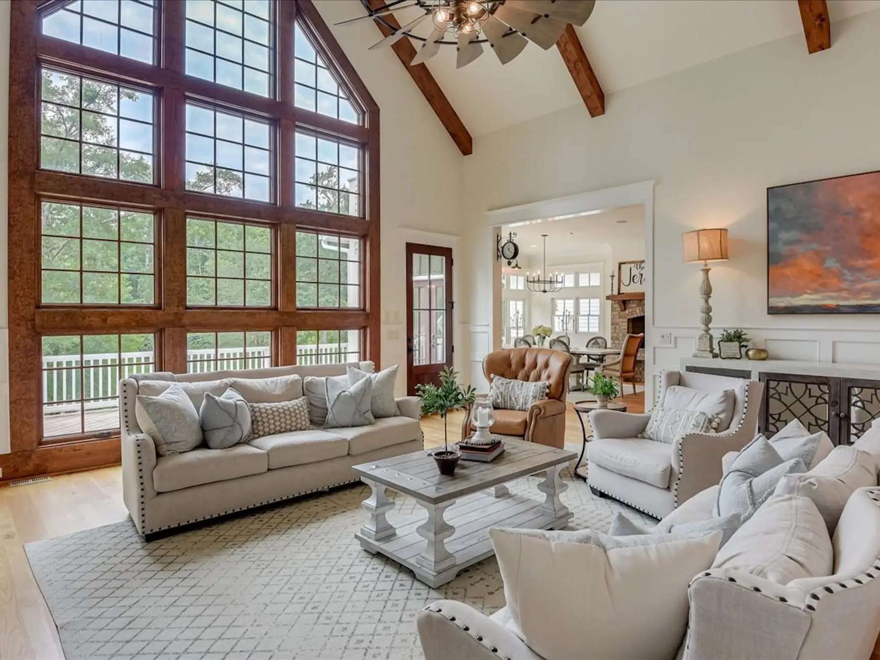 A living room with high, beamed ceilings and a wall completely covered in windows.