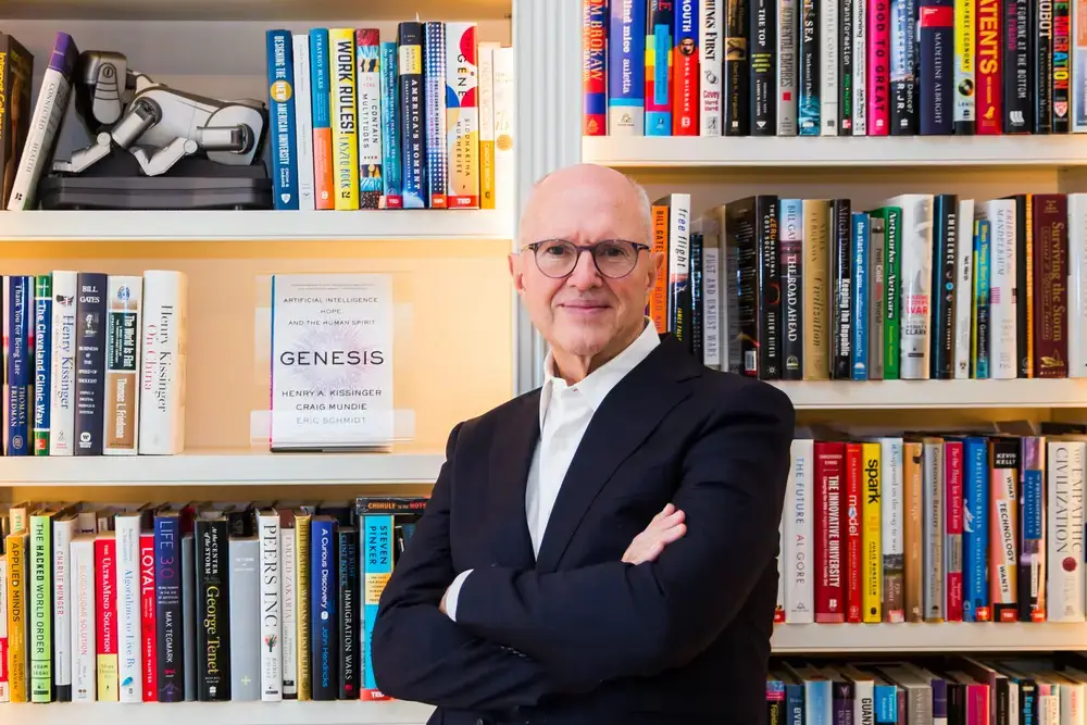 Professional phot of Craig Mundie standing in front of a colorful book shelf.