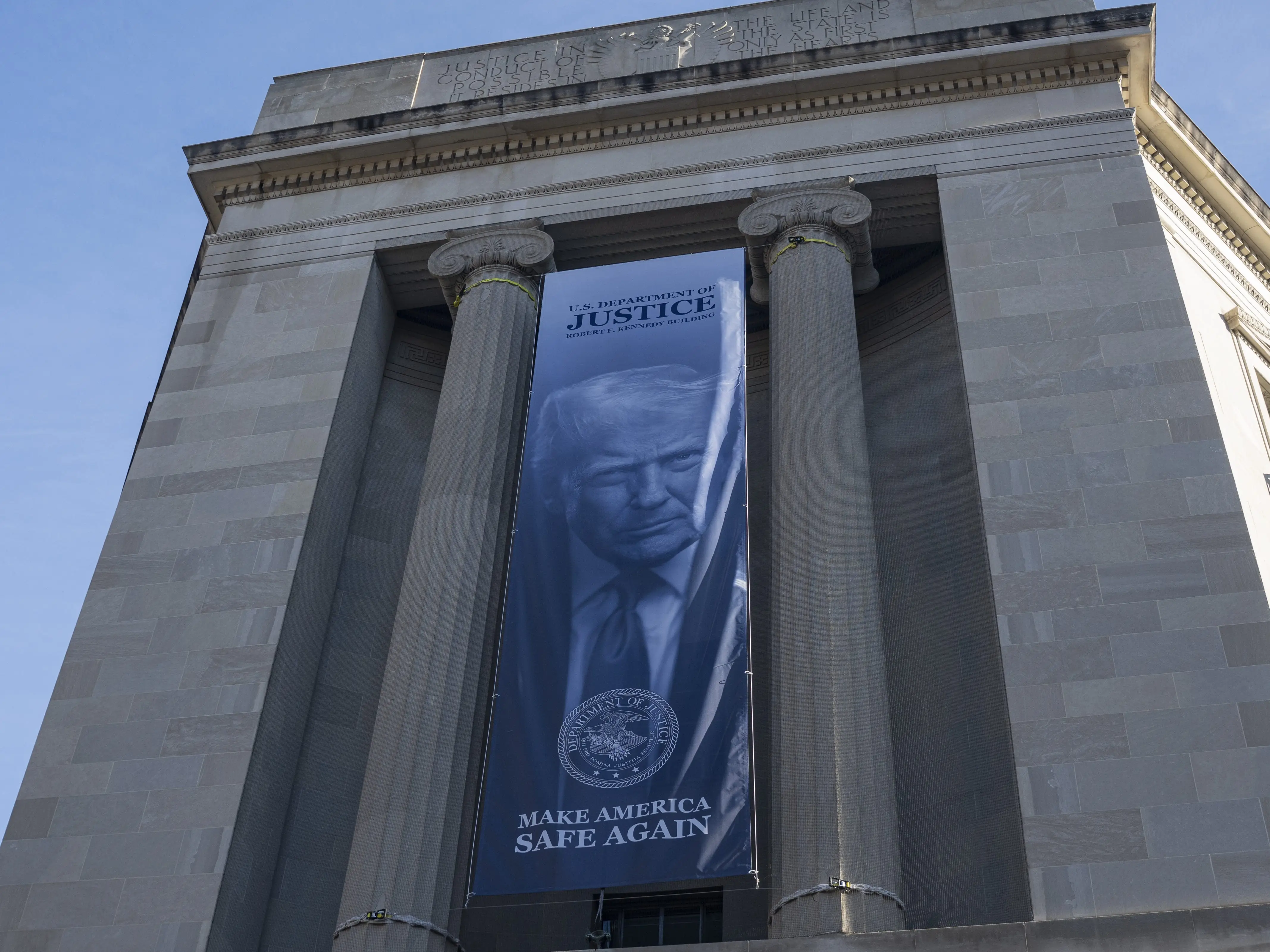 A new banner featuring an image of US President Donald Trump with the slogan 'Make America Safe Again' is displayed on the facade of the US Department of Justice headquarters in Washington DC, United States on February 20, 2026