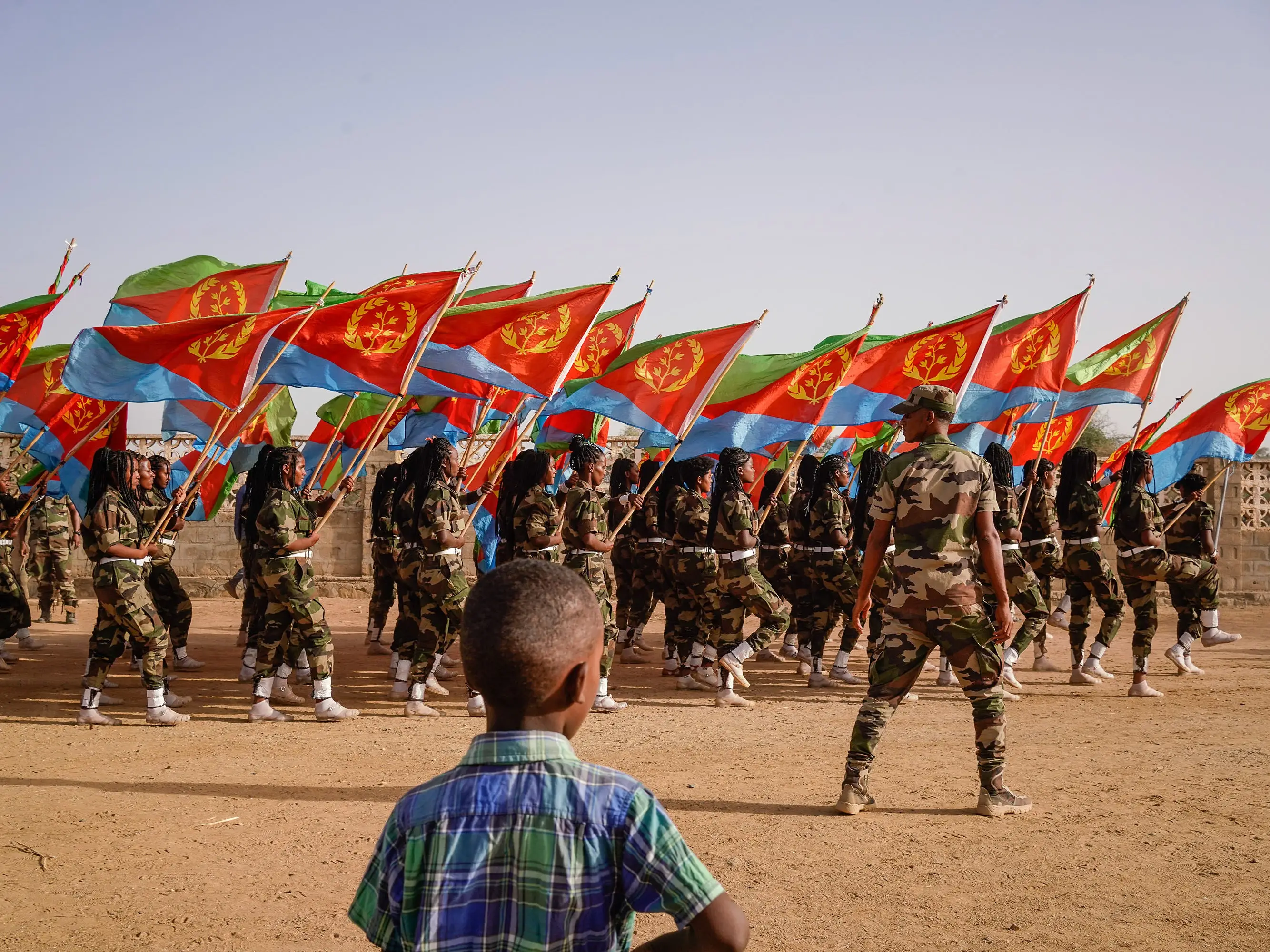 A child watches military flag-bearers walk during an Independence Day celebration in Barentu, Eritrea.