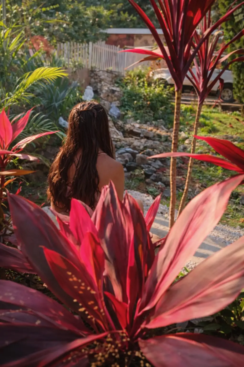 The back of a woman in the background, and flowers in the foreground.