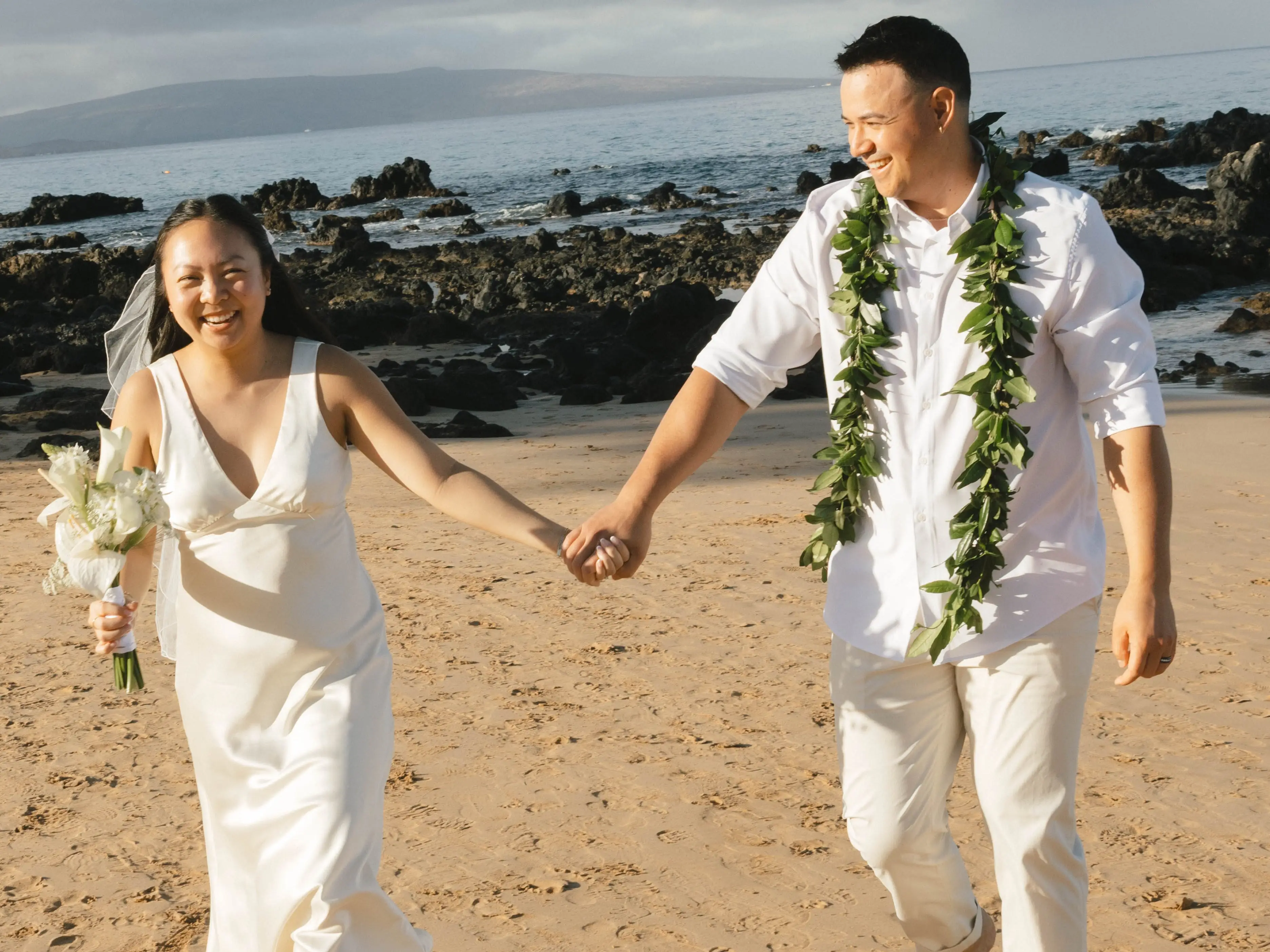 A bride and groom on a beach in Hawaii.