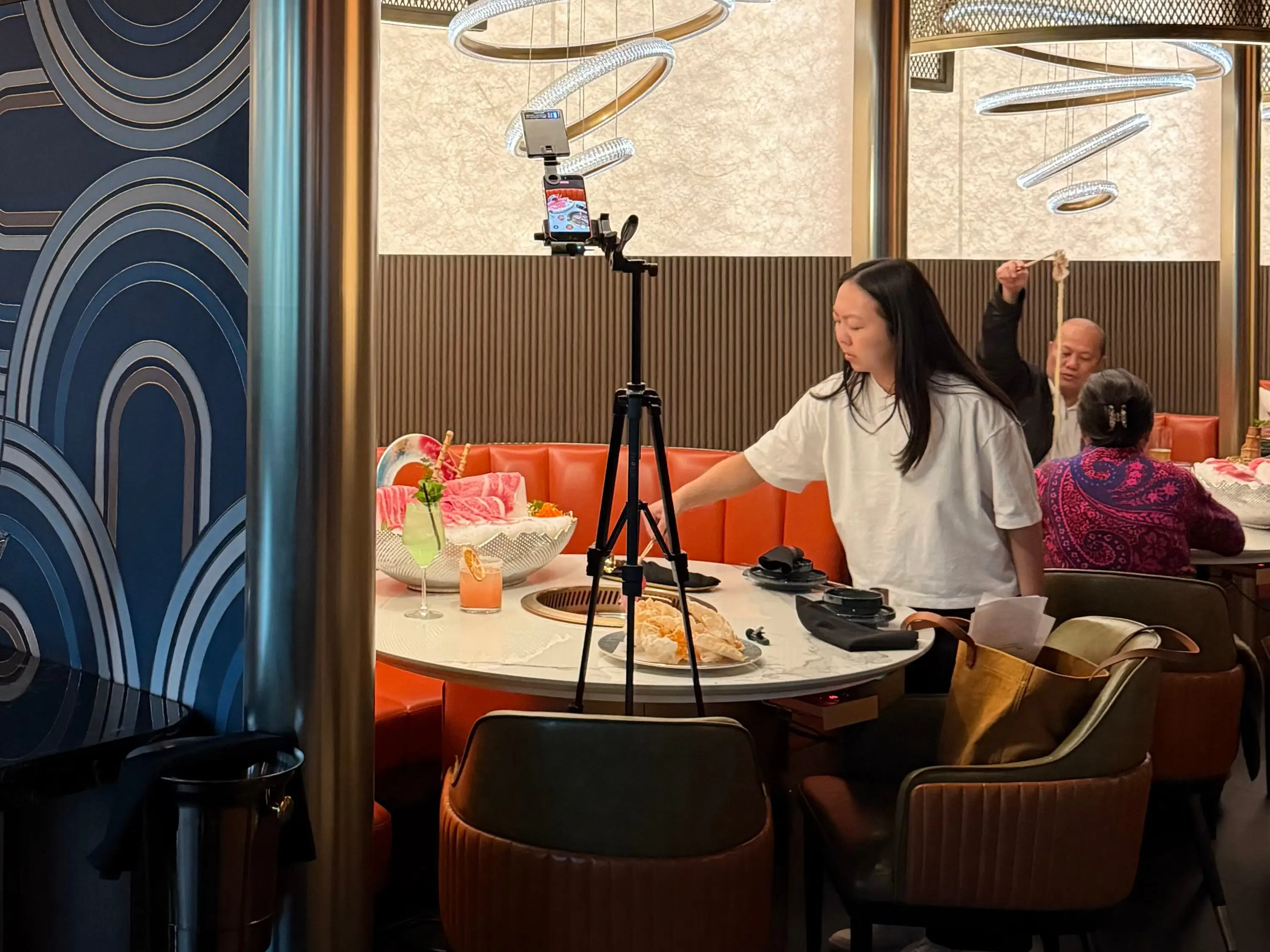 A woman is photographing food in a restaurant.