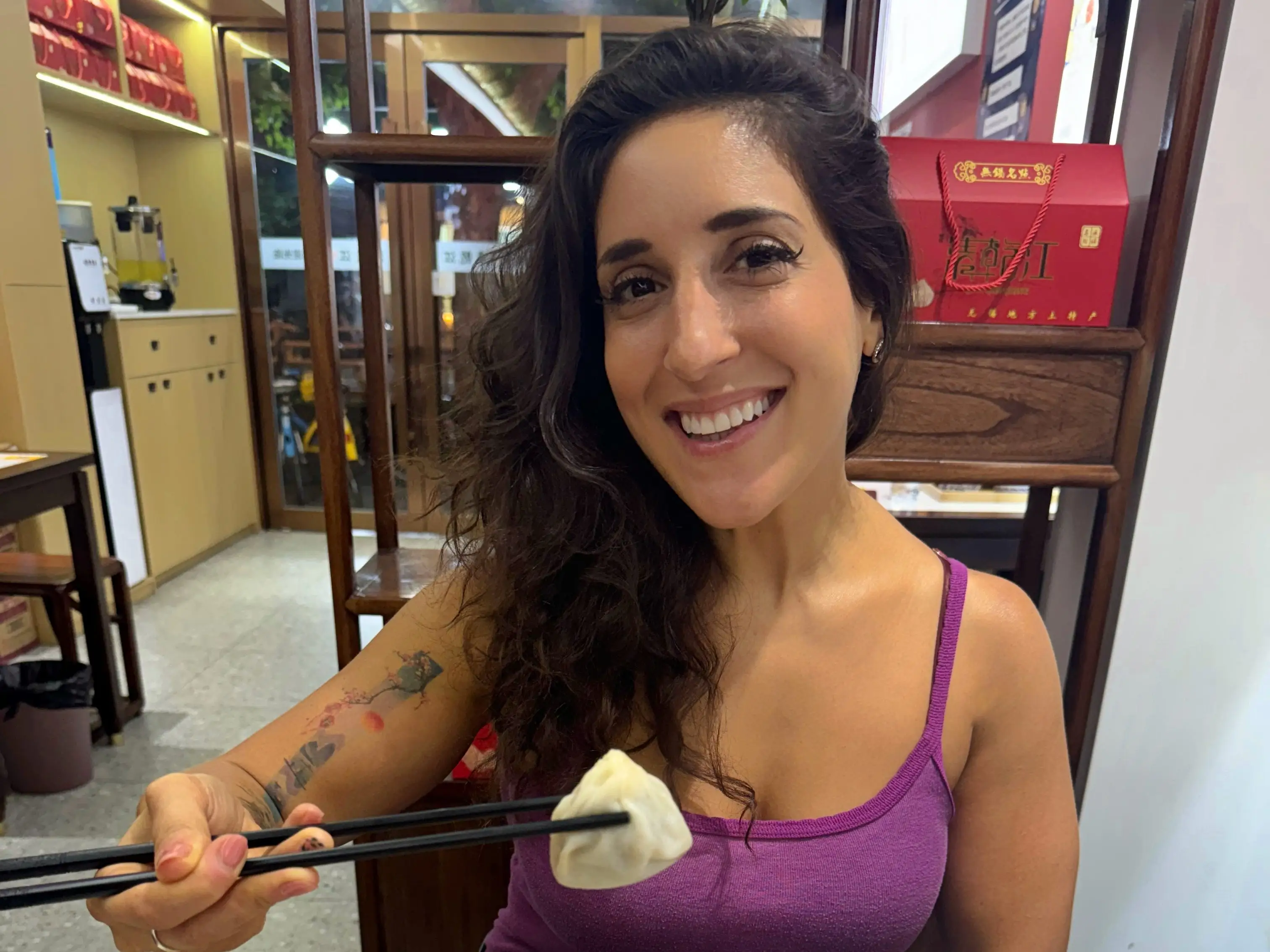 A woman eating soup dumplings in Shanghai, China.