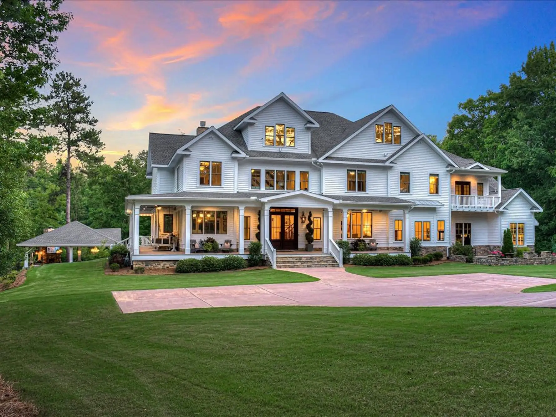 A large white house with a large green lawn.