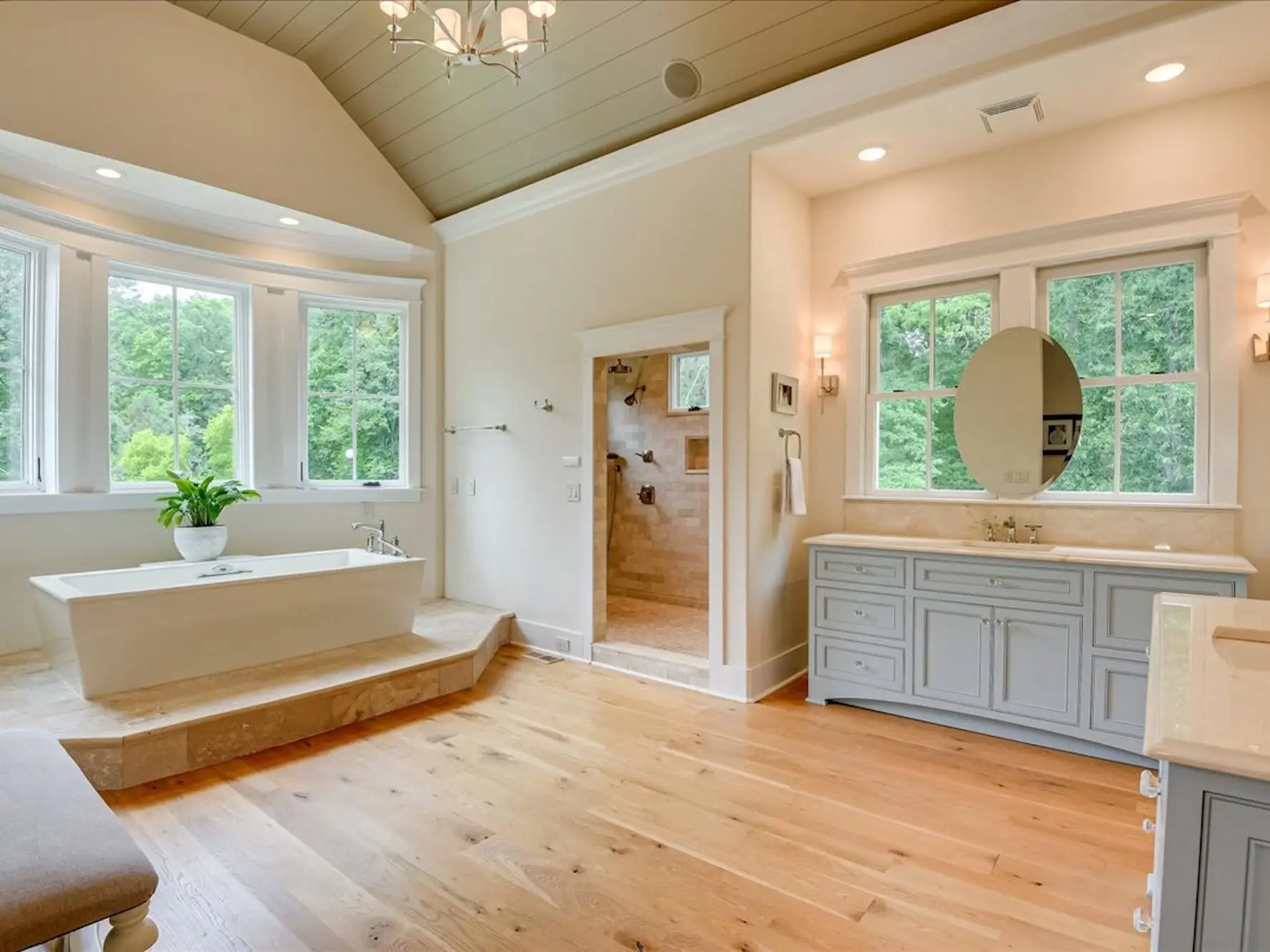 A large bathroom with a free-standing bathtub and large windows.