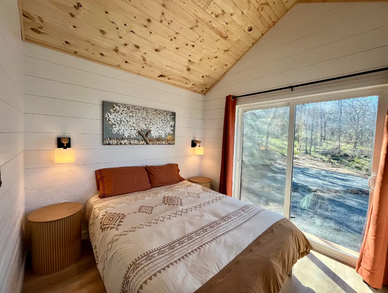 A bedroom with a high, A-framed ceiling.