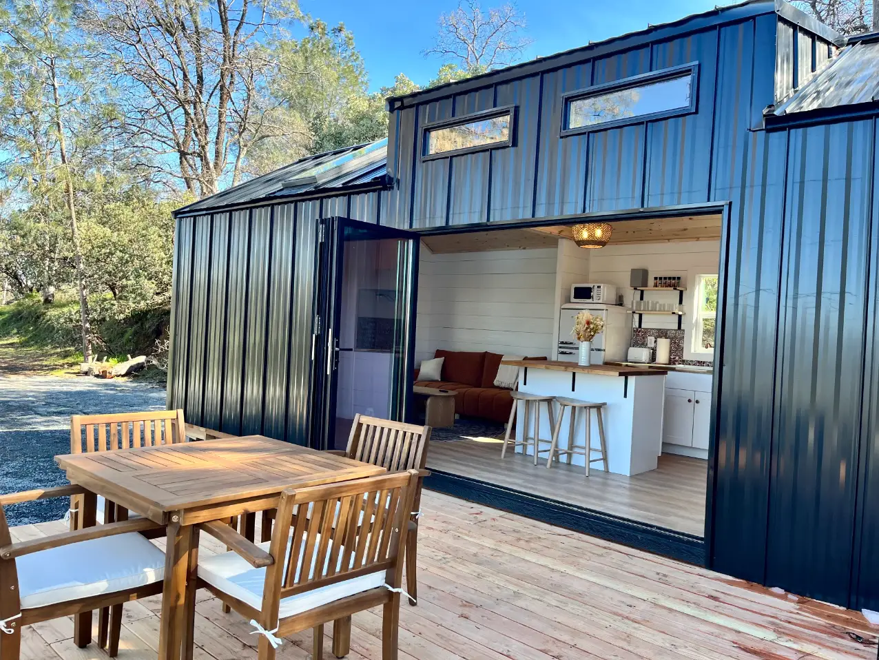 The exterior of a tiny home, with a large sliding glass door.