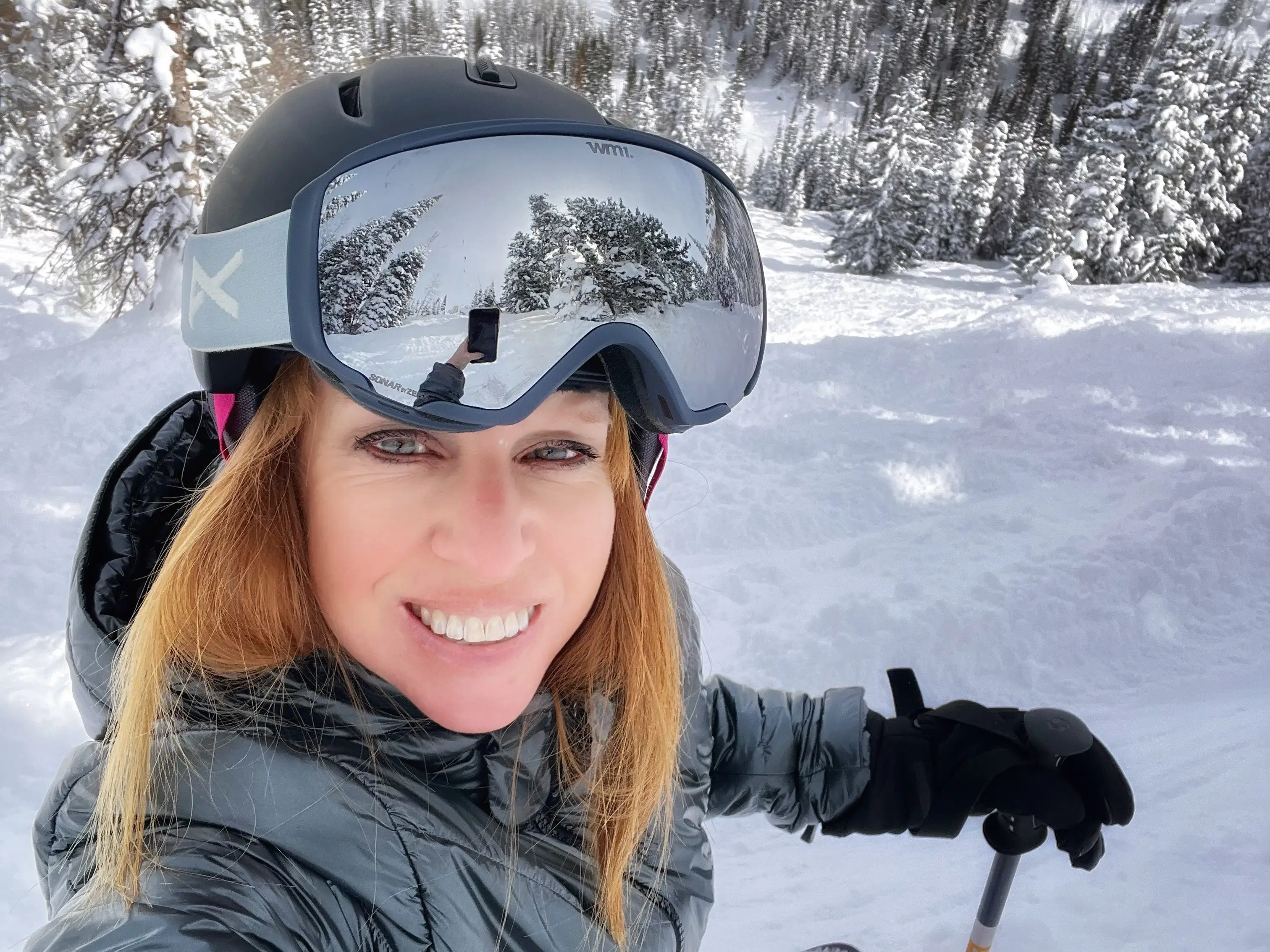 a woman takes a selfie while skiing