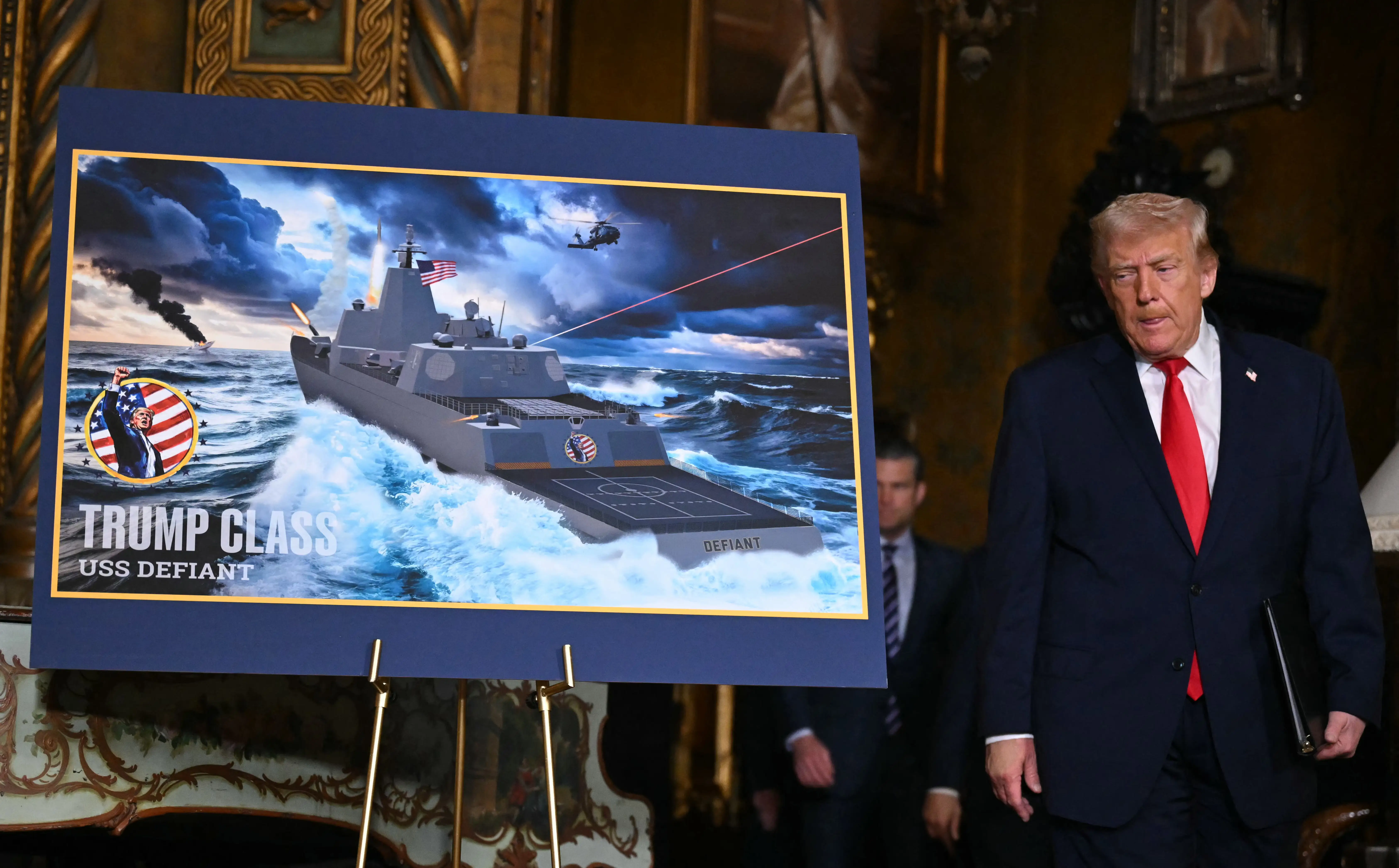 US President Donald Trump stands next to a poster showing a render of a Trump-class battleship.