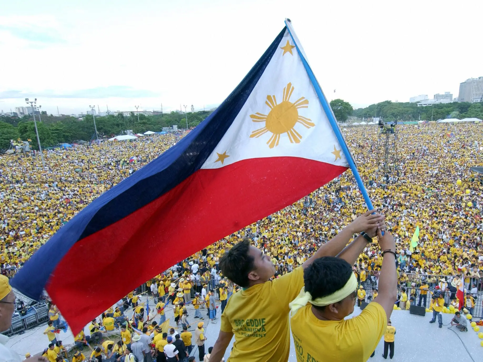 Supporters of Philippine presidential candidate Eduardo Villanueva wave the Philippine flag in front of a crowd in 2004.