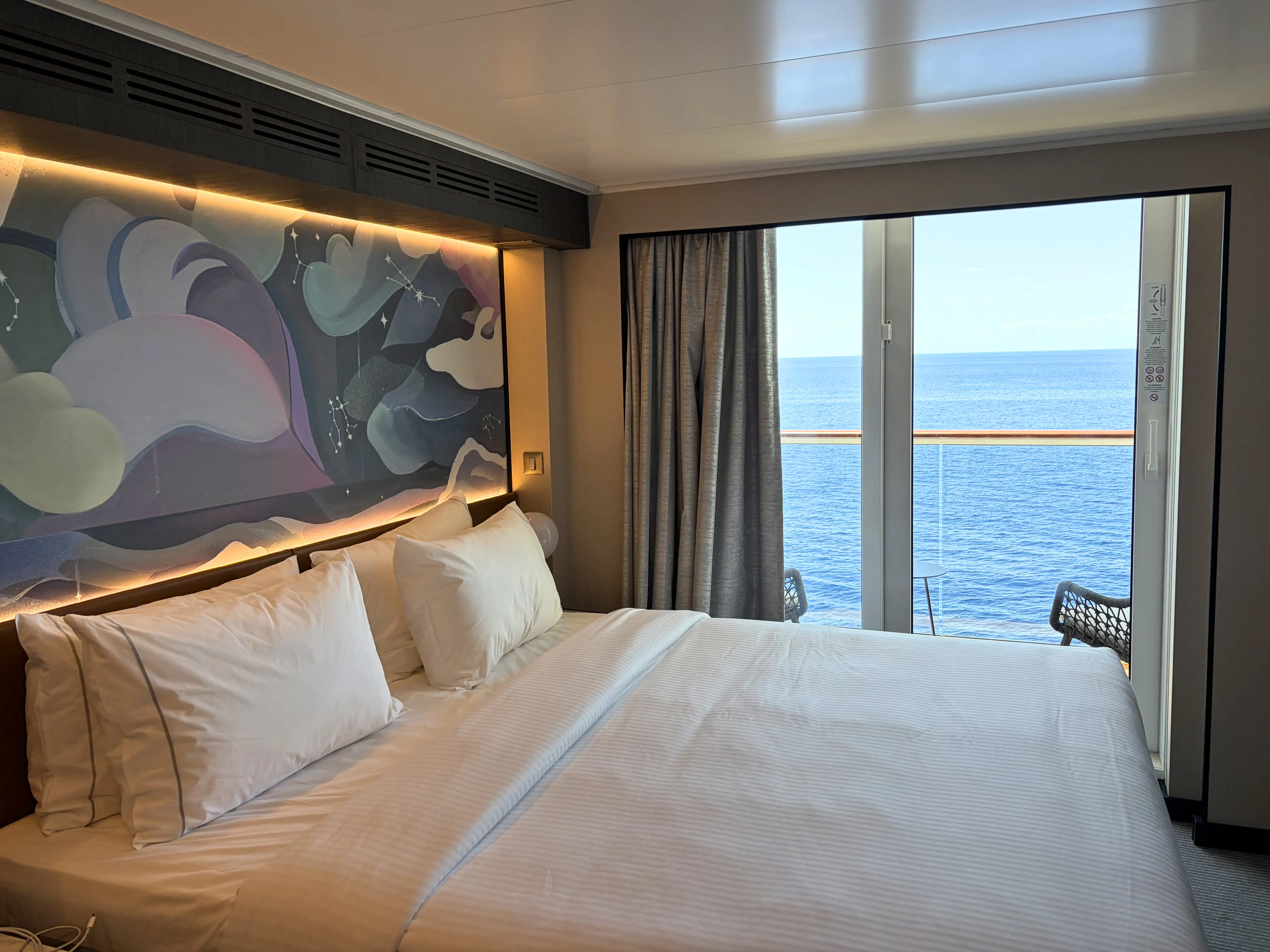 view of bed, baclony doors in room on Norwegian Luna