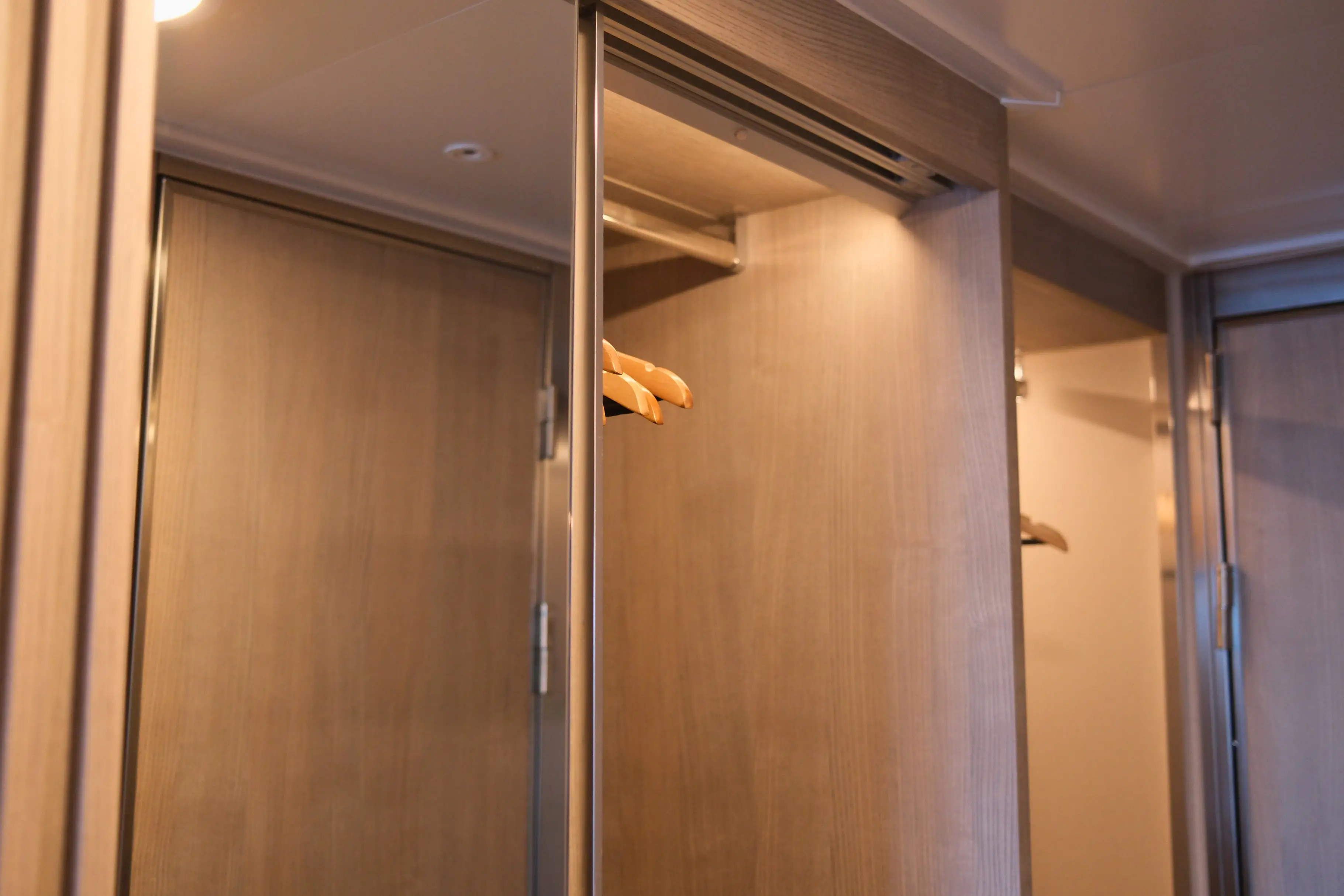 Mirrored closet doors with hangers visible inside