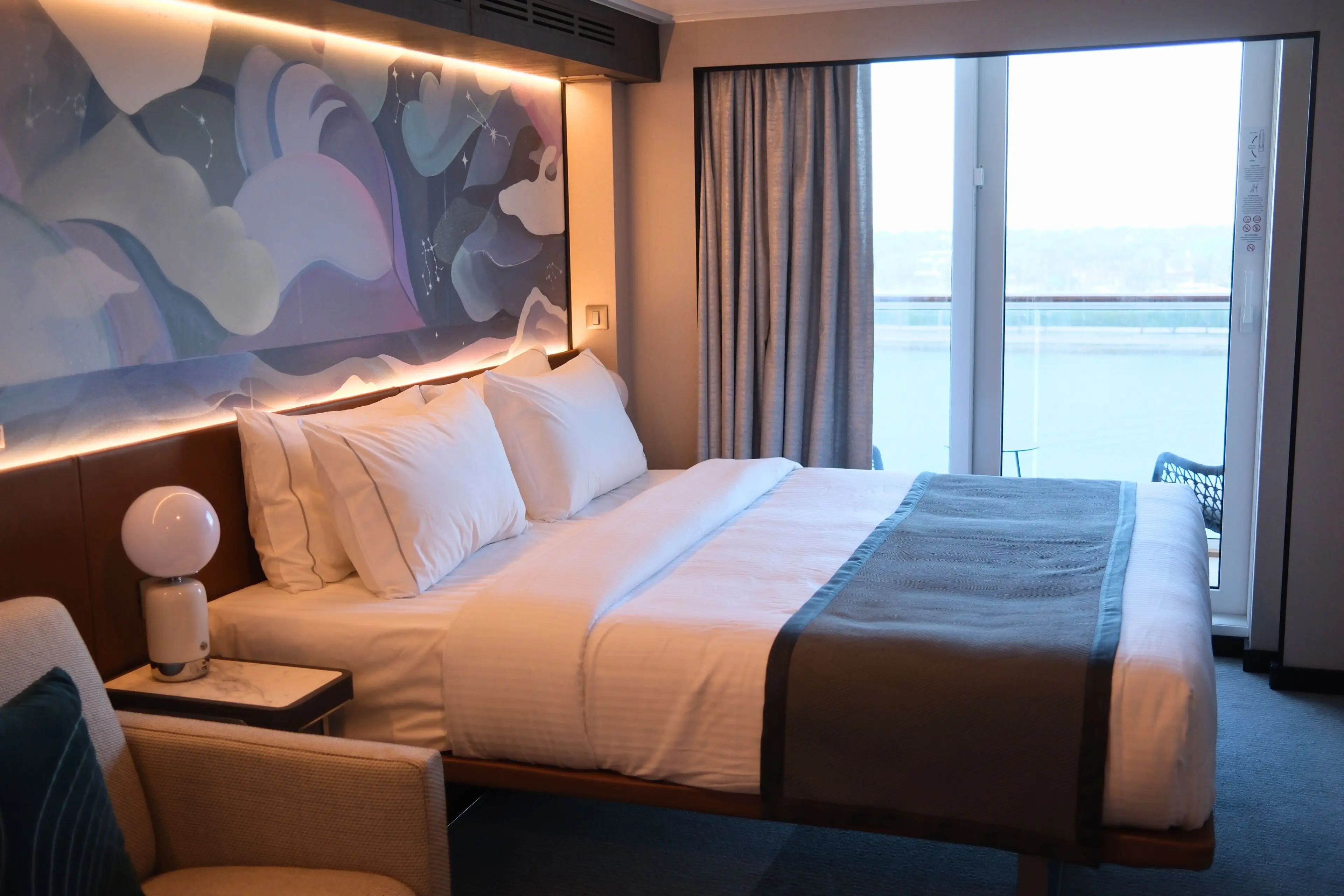 View of bed, baclony door  in room on Norwegian Luna