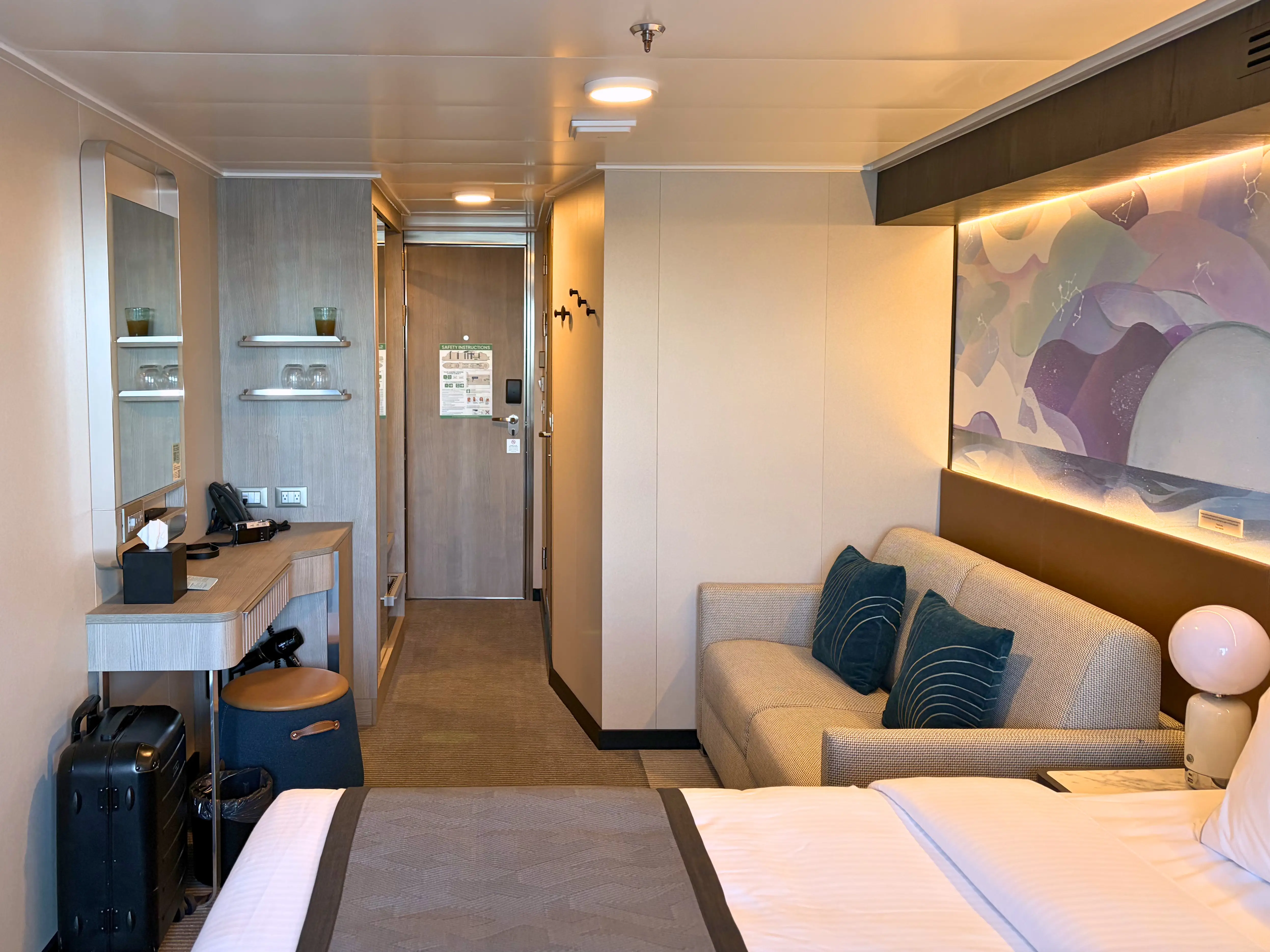 View of vanity area, couch, doorway in room on Norwegian Luna