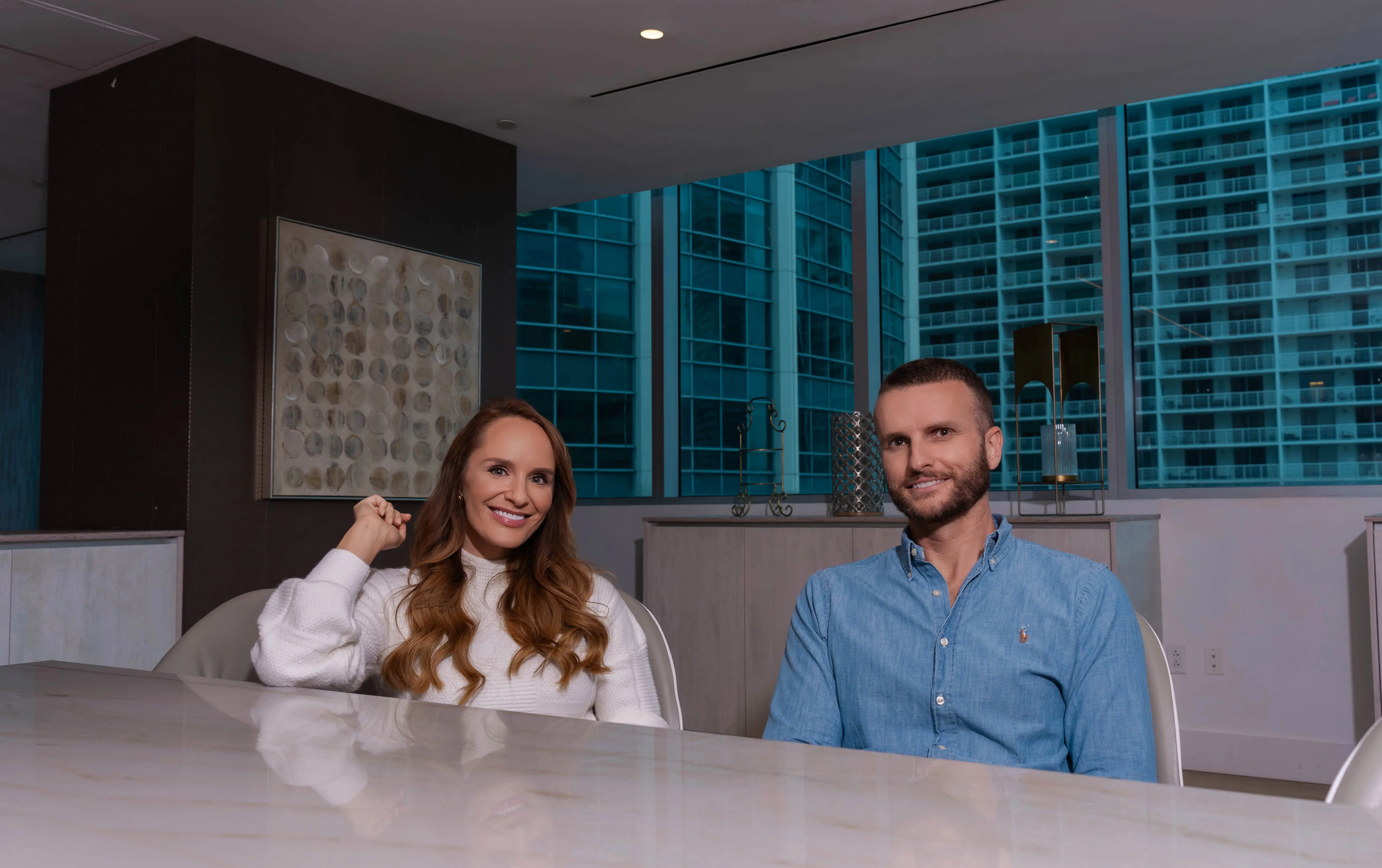 a married couple poses in a board room