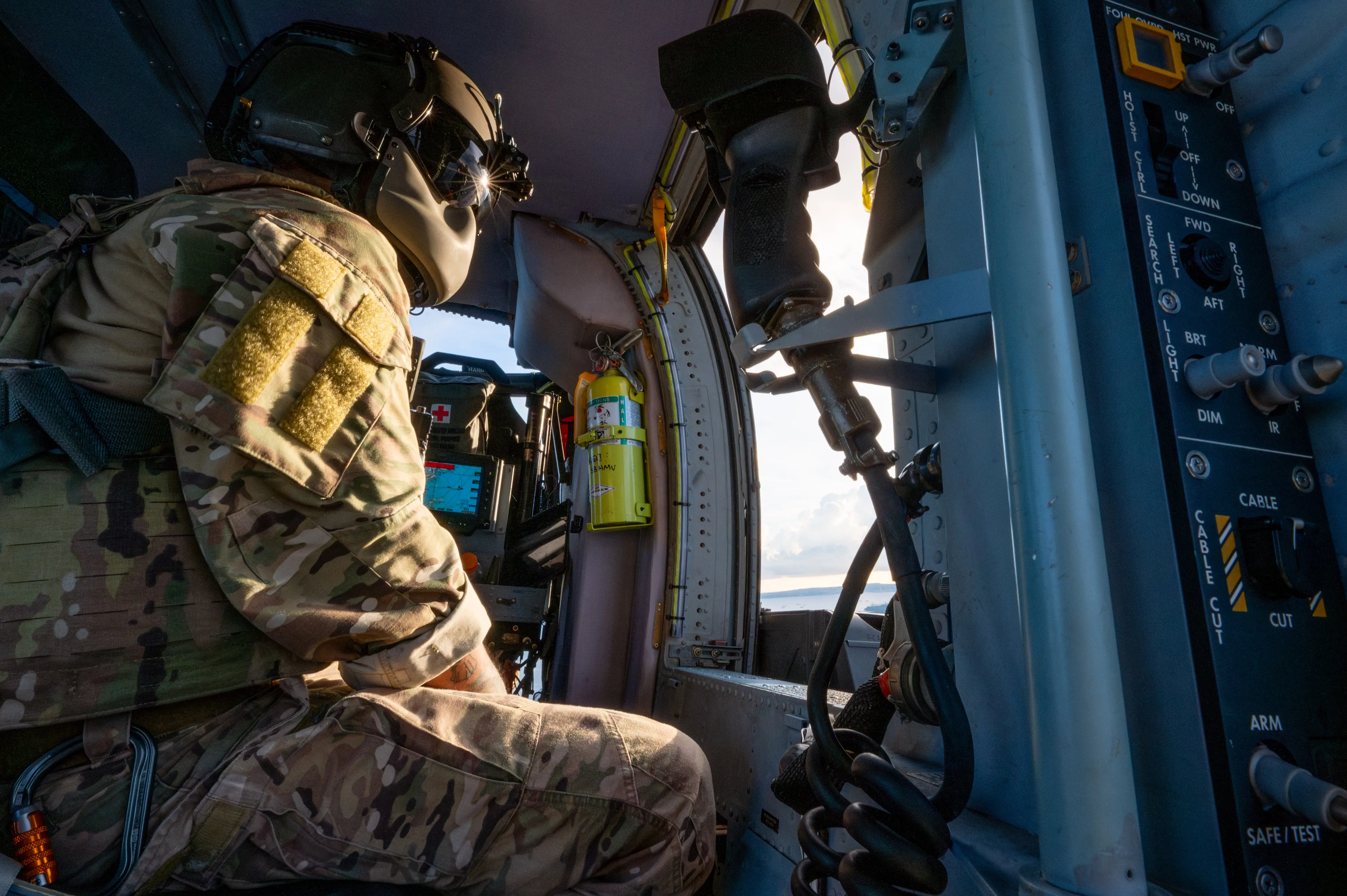 A special mission aviator looks out of an HH-60W Jolly Green II after a personnel recovery exercise.